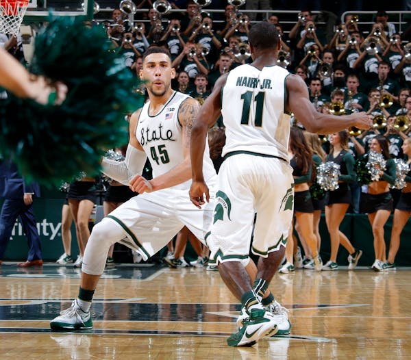 Michigan State's Denzel Valentine (45) and Lourawls Nairn Jr. (11) celebrate following a 71-67 win over Louisville in an NCAA college basketball game,