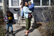 Mercedes Yarbrough picked up her children Meir, 2, and Matthew, 5, from daycare on Wednesday in St. Paul. Behind them, Rosalyn Smaller, who runs the d