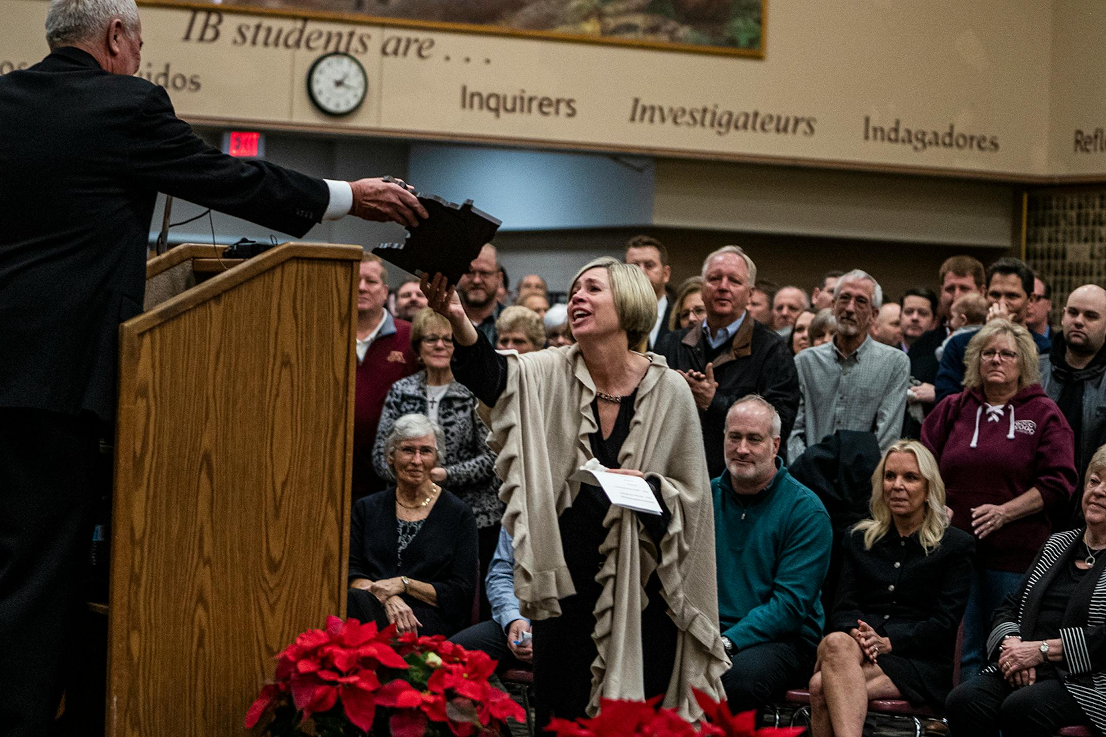 U of M Regent Dave Metzen handed Amy Woog Patnode a plaque in honor of her father during a celebration of Gophers hockey legend Doug Woog at South St. Paul High School.