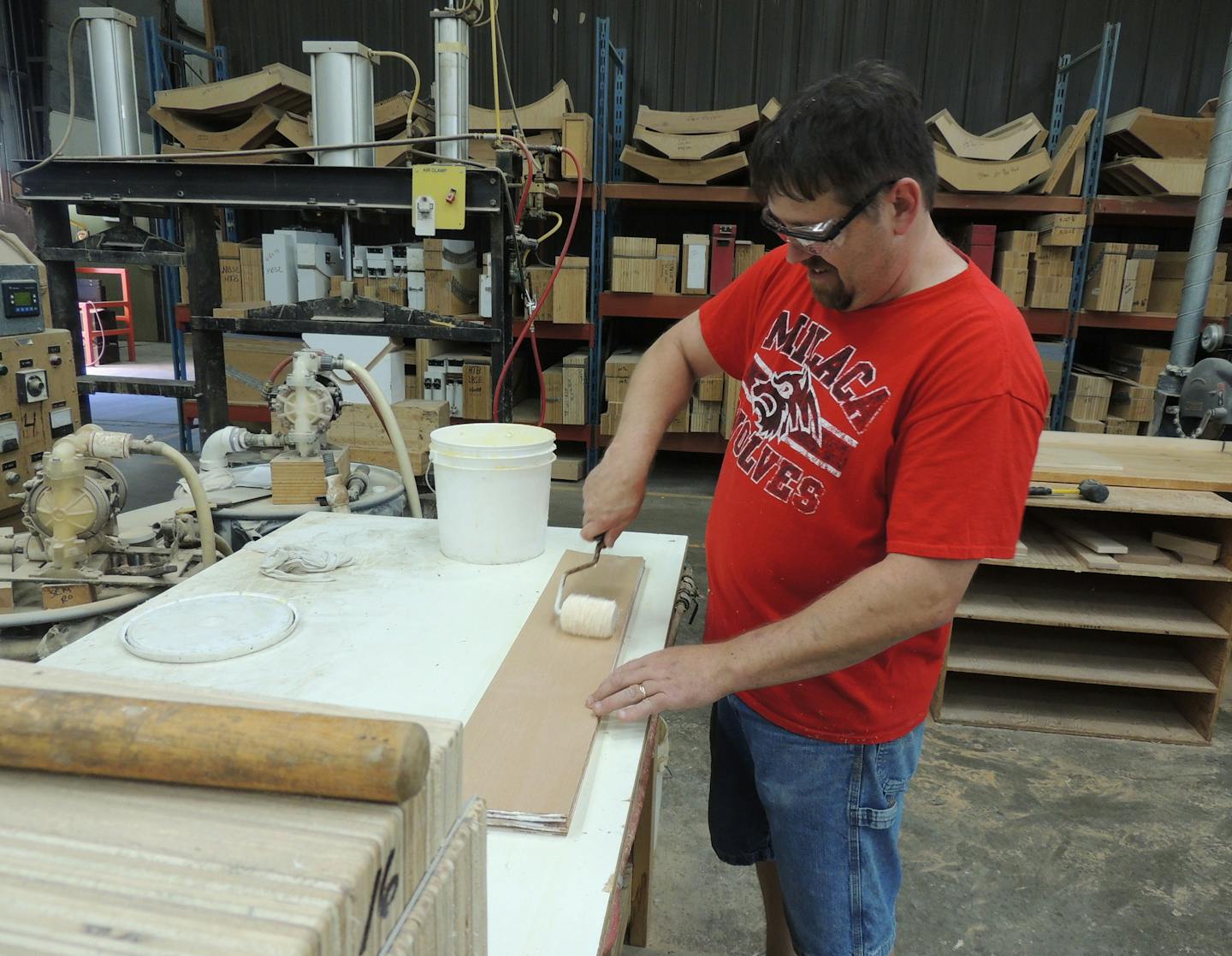 Crystal Cabinet Works employee Robert Volk glues 1/18th inch wood &#xec;skins&#xee; or flitches together as part of the process of building a radius door.