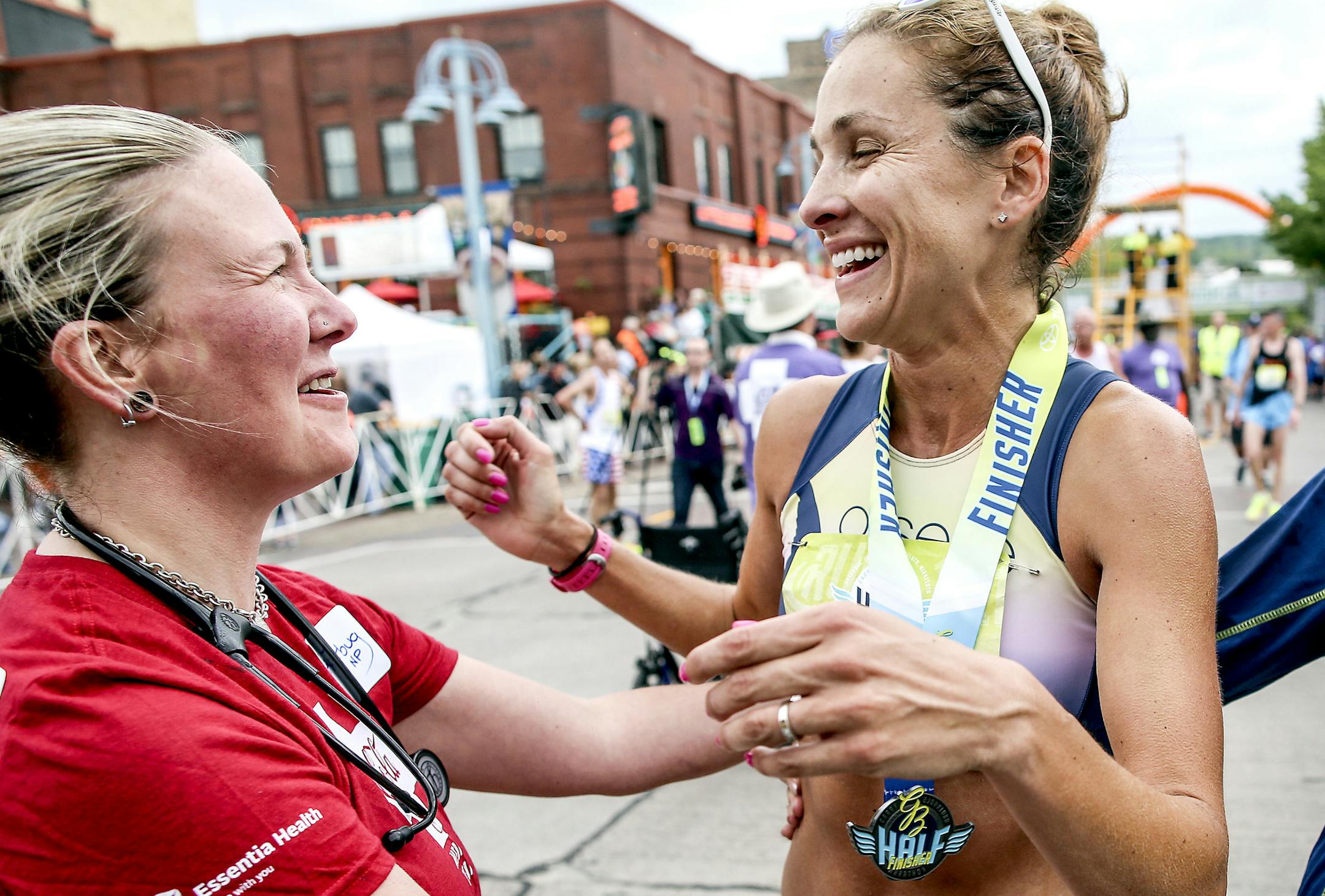 t051917 --- Clint Austin --- 091917.N.DNT.GRANDMAS.C60 --- Jitterbug Pierce congratulates Kara Goucher at the finish line of the Garry Bjorklund Half Marathon Saturday morning in Duluth. (Clint Austin / caustin@duluthnews.com)