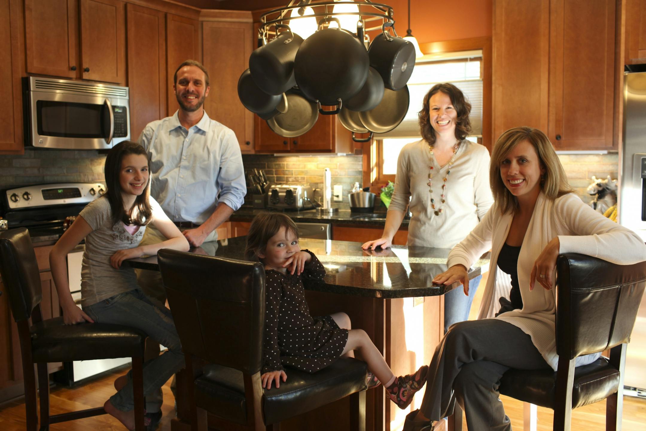 The Schullers in their new kitchen. They are, from left, Olivia, 11, Dave, Josephine, 2.5, and Colleen. At right is Colleen's cousin, A. J. Paron-Wildes, a designer who initiated the project.