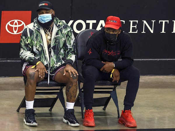 Houston Texans quarterback Deshaun Watson, right, watches an NBA basketball game between the Los Angeles Lakers and the Houston Rockets on Tuesday, Ja