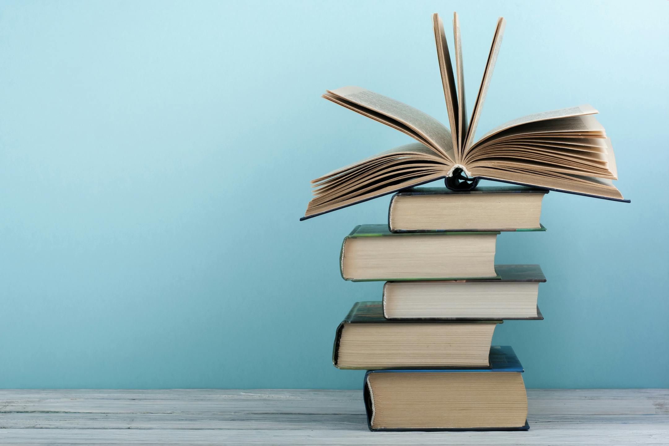 Stack of colorful books. Education background. Back to school. Book, hardback colorful books on wooden table. Education business concept. Copy space for text