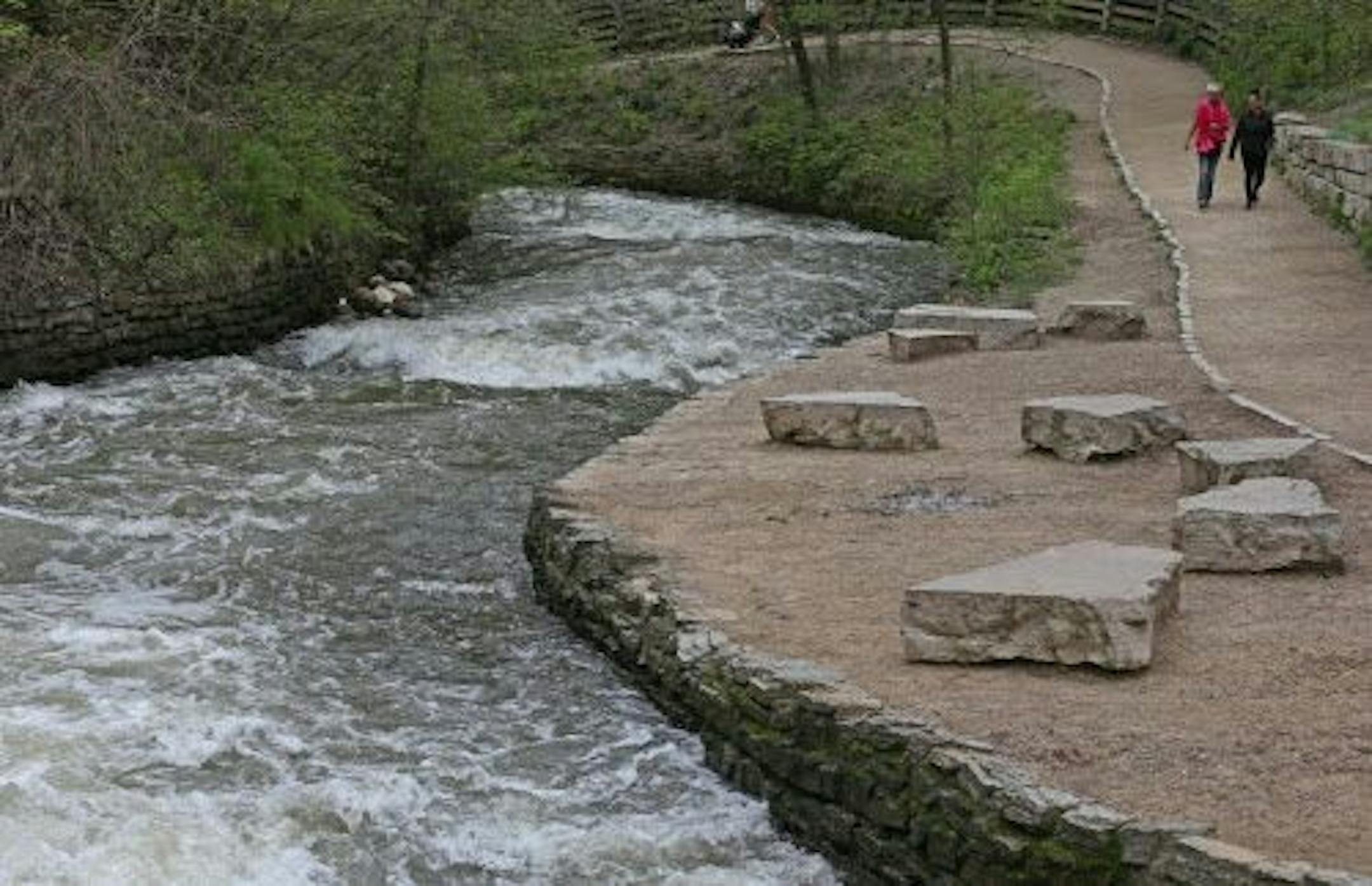 (left to right) Ashley Nicholls of Roseville and Selena Eischens of St. Paul walked next to a roaring Minnehaha creek, just below the Minnehaha Falls on 5/23/14. Just ahead of the Memorial Day weekend, authorities announced Wednesday that Minnehaha Creek is not safe for canoeing or kayaking due to high water levels. The 22-mile creek runs through Minnetonka, Hopkins, St. Louis Park, Edina and Minneapolis.