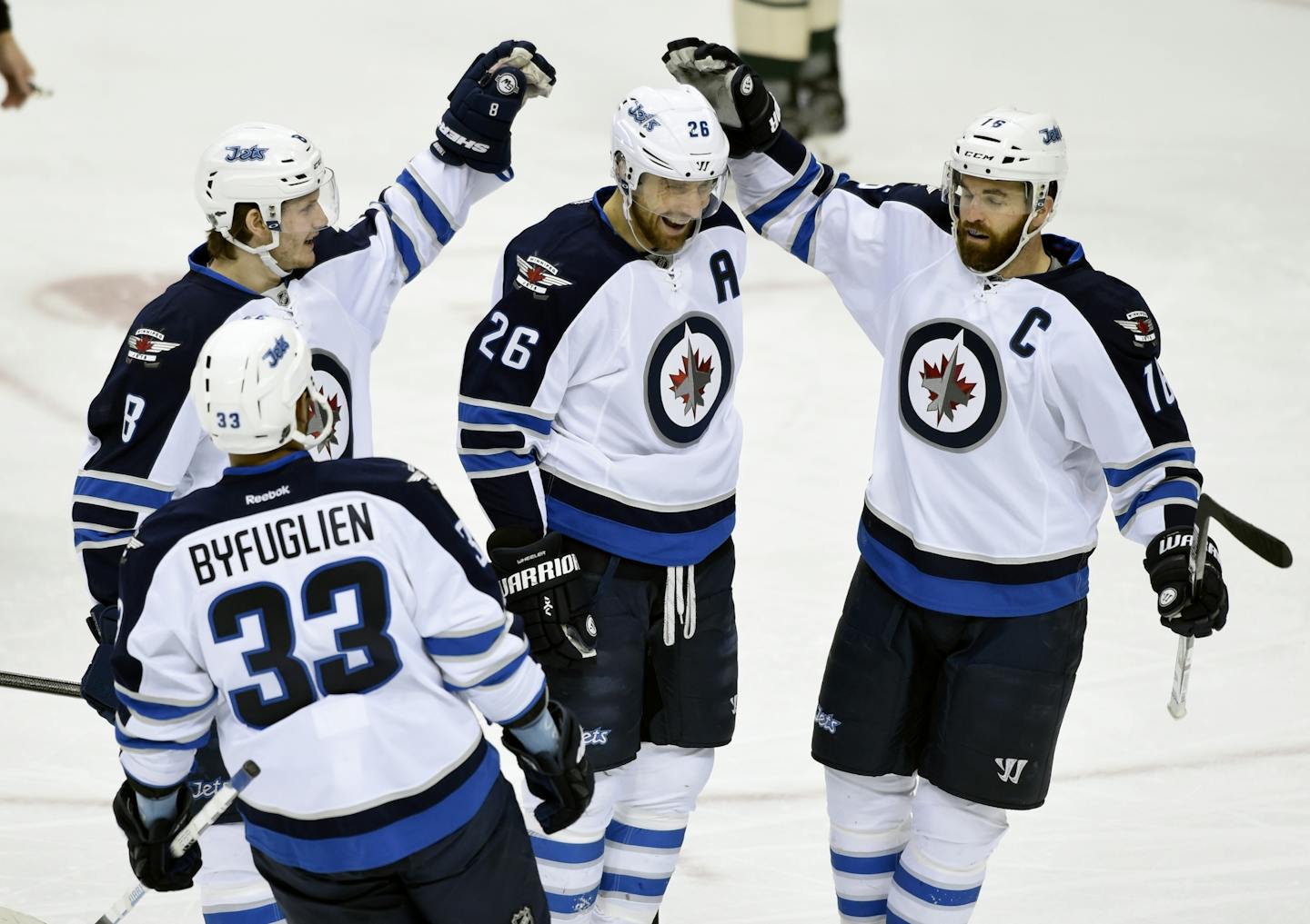 Winnipeg Jets' Dustin Byfuglien (33), Jacob Trouba (8) and Andrew Ladd (16) congratulate right wing Blake Wheeler (26) on a goal against the Minnesota Wild during the first period of an NHL hockey game Friday, Jan. 15, 2016, in St. Paul, Minn.