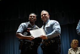 Officer Jamal Mitchell, left, was photographed in a 2023 Minneapolis Police awards ceremony where he was presented with a Lifesaving Award by Chief Br