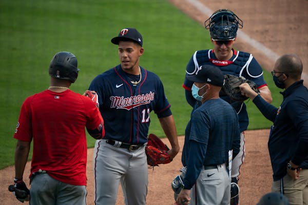 Minnesota Twins pitcher Jose Berrios and Twins infielder Luis Arraez fist bumped as Berrios and catcher Mitch Garver came off the field after throwing