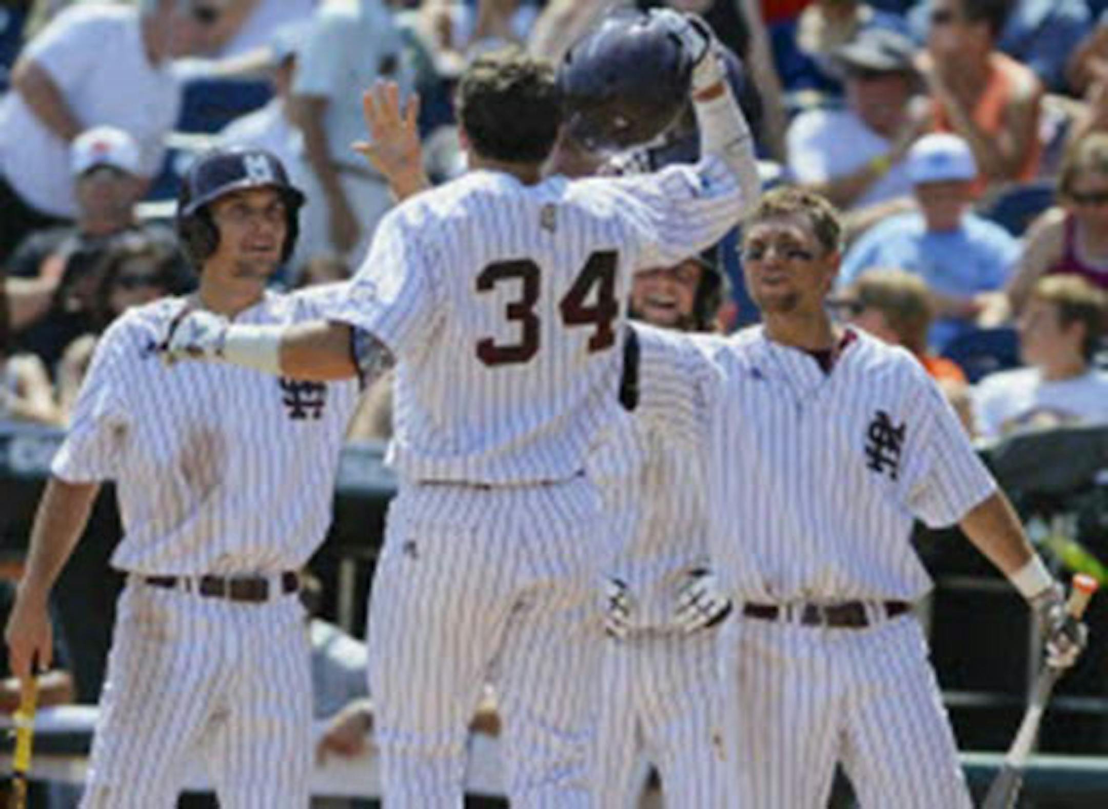 Mississippi State's Hunter Renfroe (34) was greeted by teammates, including Adam Frazier, left, after hitting a three-run home run against Oregon State in the fifth inning of an NCAA College World Series baseball game in Omaha, Neb., on Friday.