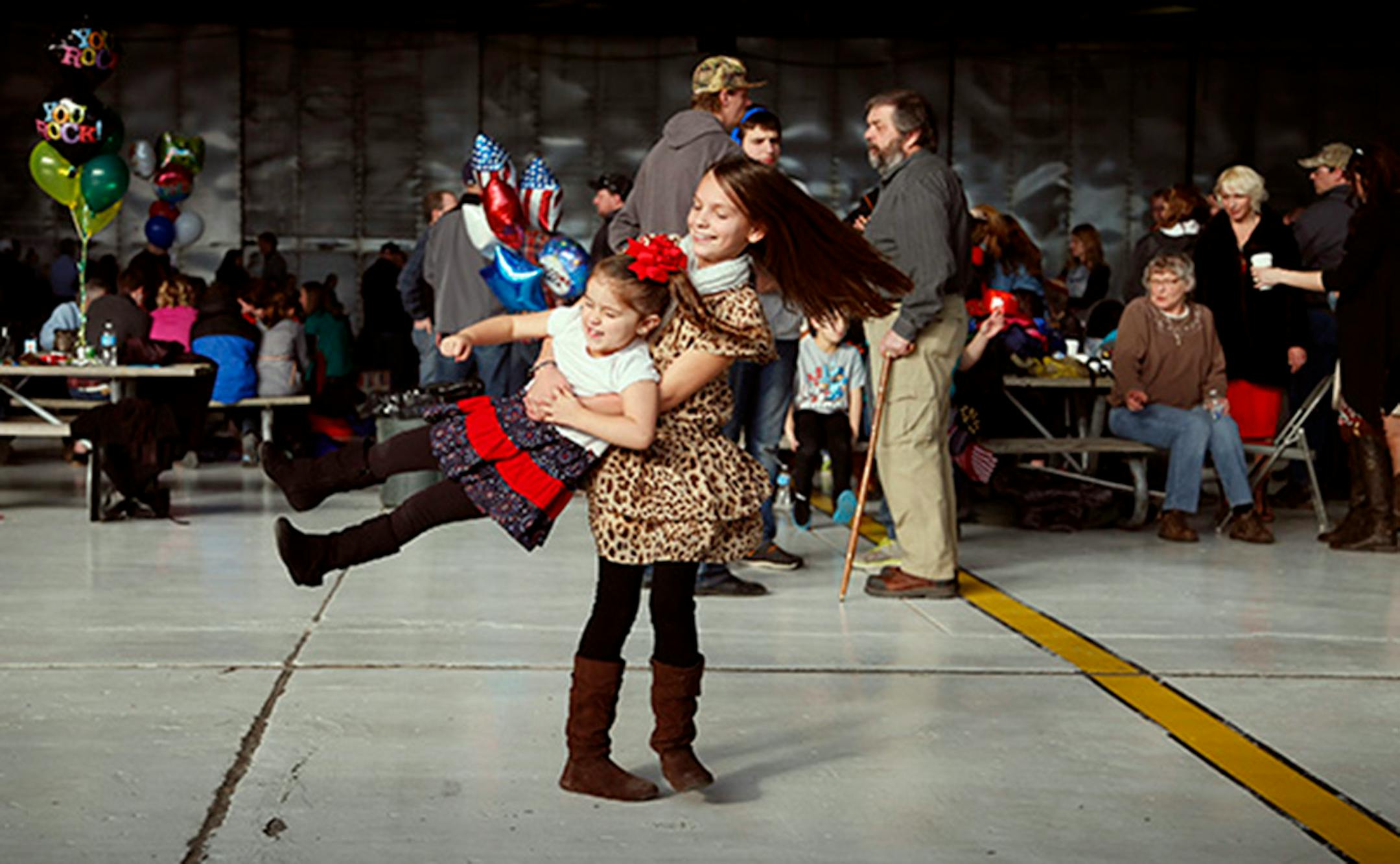 Jocelyn Rettmann 11, swung her cousin Aubrey Leier 3 around as they waited for her father Benjamin Rettmann to arrive from his deployment. Families gather for the arrival of the more than 100 Airmen and three C-130 H3 Hercules aircraft from the 934th Airlift Wing, Air Force Reserve, return from their deployment to Southwest Asia after their four-month tour of duty. Sunday January 18, 2015 Minneapolis, MN.] Jerry Holt/ Jerry.Holt@Startribune.com