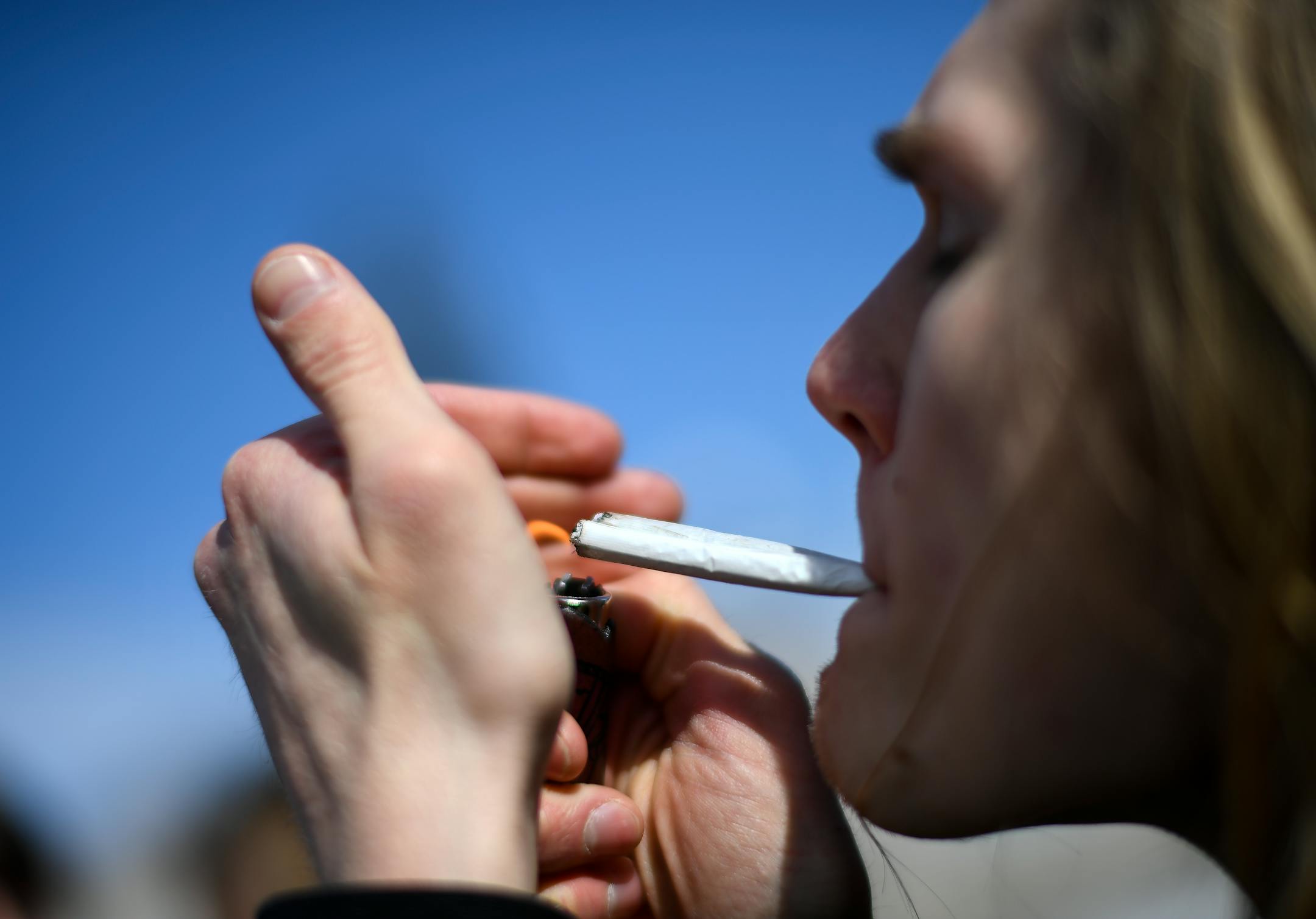 A man lights up a pair of joints on April 20, 2018, on the steps of the Minnesota Capitol during Cannabis Awareness Day.