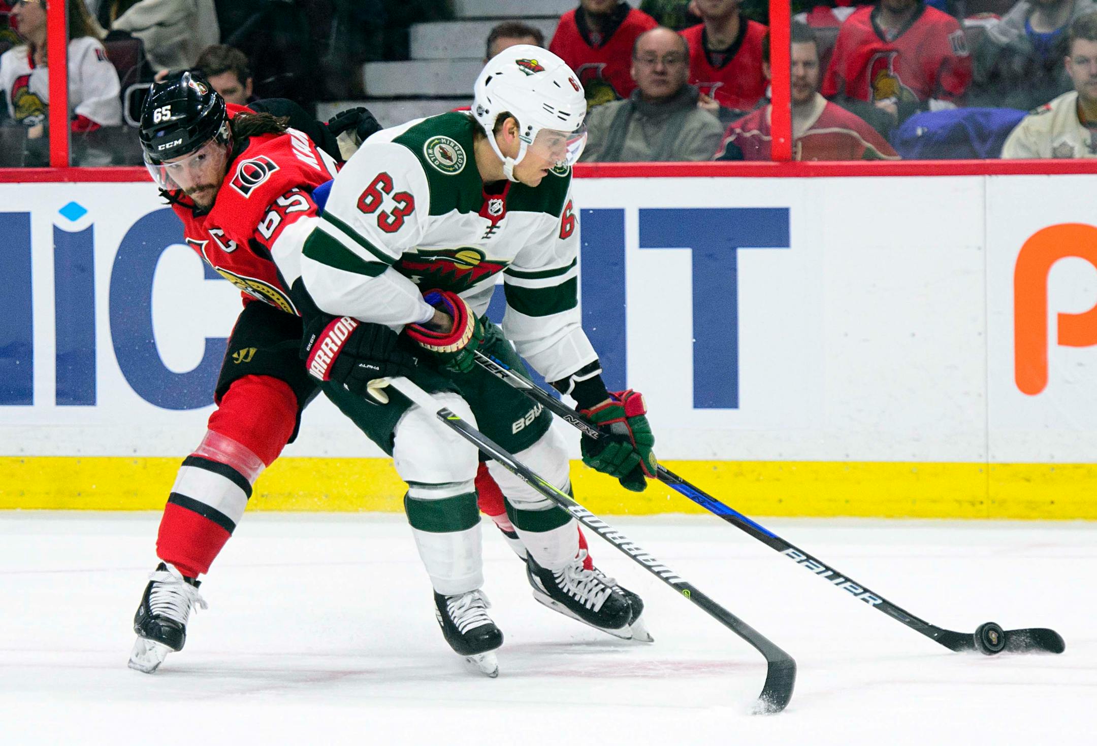 Minnesota Wild's Tyler Ennis, right, works to keep the puck away from Ottawa Senators' Erik Karlsson during first period NHL hockey action in Ottawa on Tuesday, Dec. 19, 2017. (Sean Kilpatrick/The Canadian Press via AP)