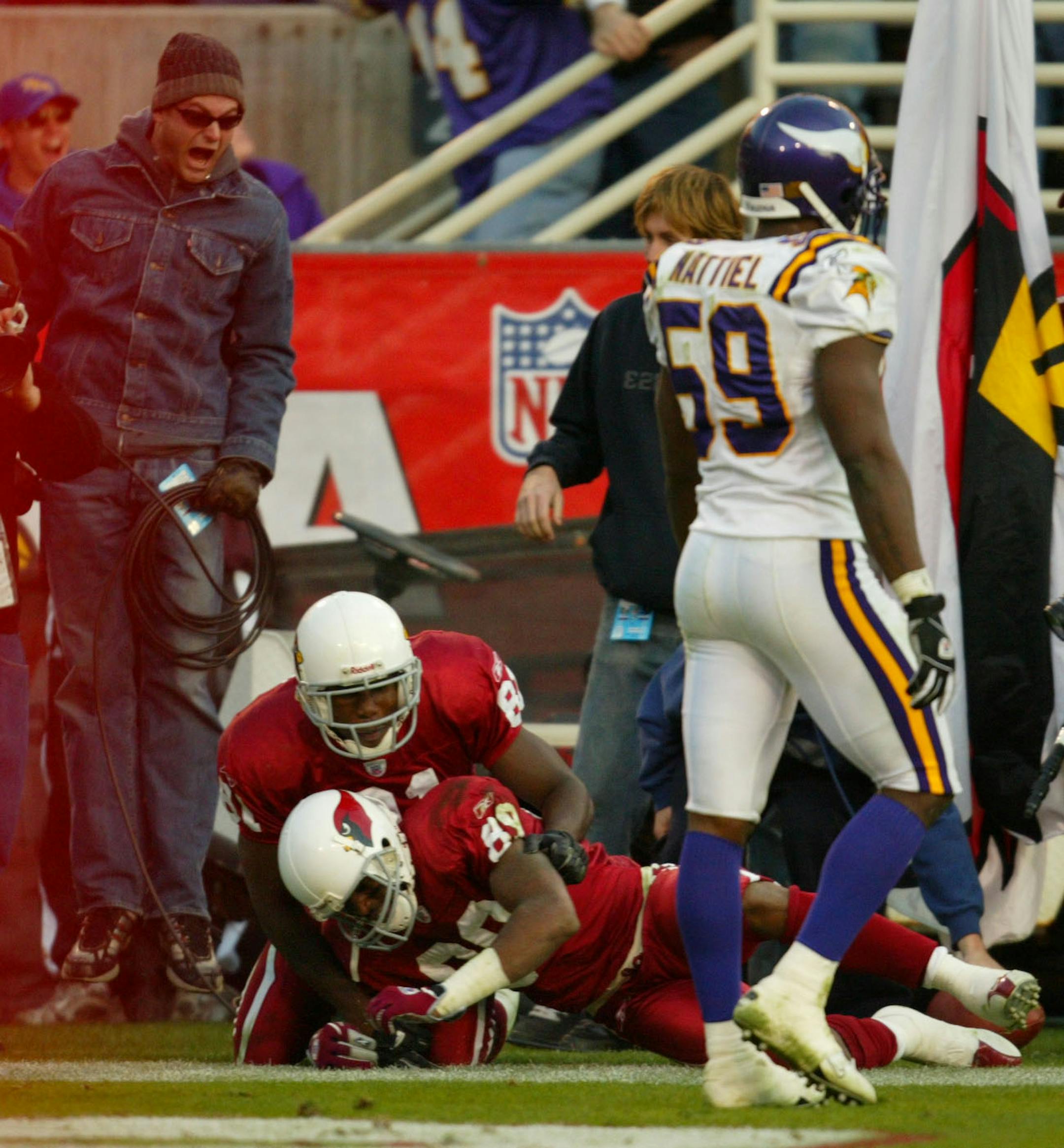 The Cardinals Anquan Boldin (81) grabs teammate Nathan Poole (89) to start celebrating the Cardinals' upset win over the Vikings Sunday. The Vikings Mike Nattiel (59) is at right.