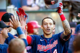 Minnesota Twins' Carlos Correa, right, is congratulated after hitting a solo home run against the Los Angeles Angels during the first inning of a base