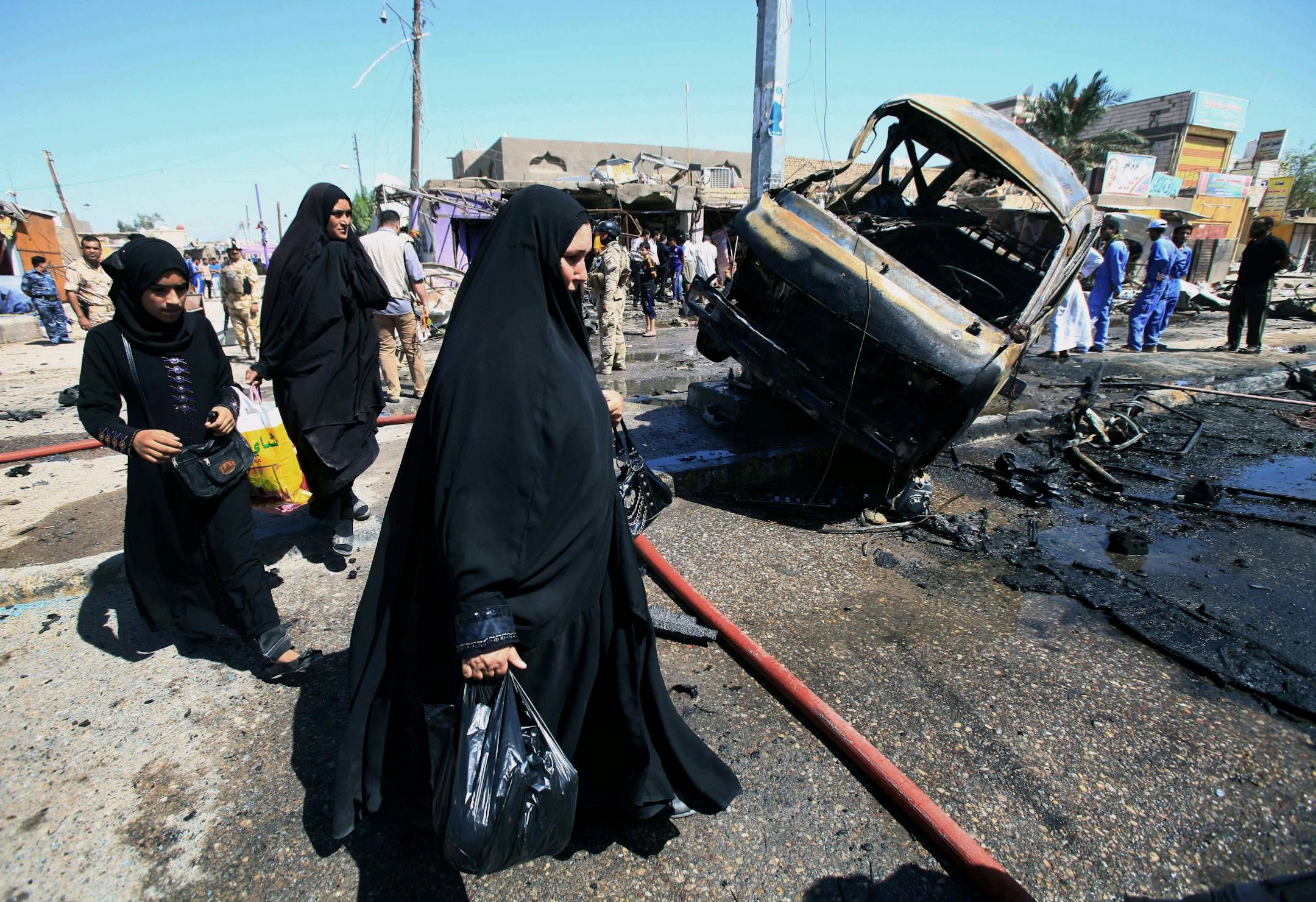 People inspect the site of a car bomb explosion in Basra, 340 miles (550 kilometers) southeast of Baghdad, Iraq, Monday, July 29, 2013.