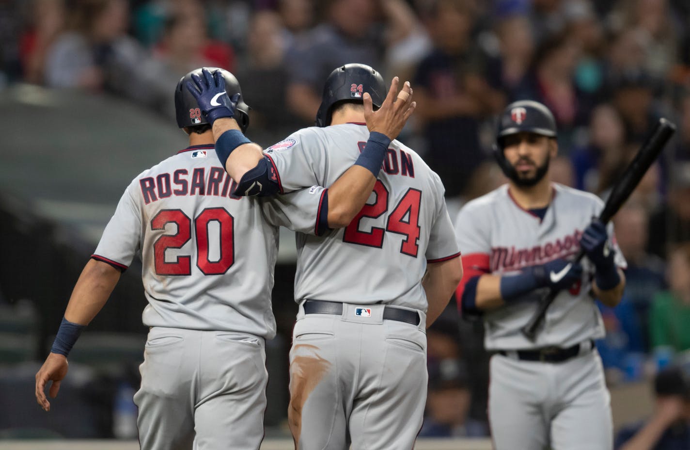 Minnesota Twins' Eddie Rosario, left, and C.J. Cron celebrate after Cron hit a two-run home run off of Seattle Mariners starting pitcher Erik Swanson during the fourth inning of a baseball game Thursday, May 16, 2019, in Seattle. (AP Photo/Stephen Brashear)