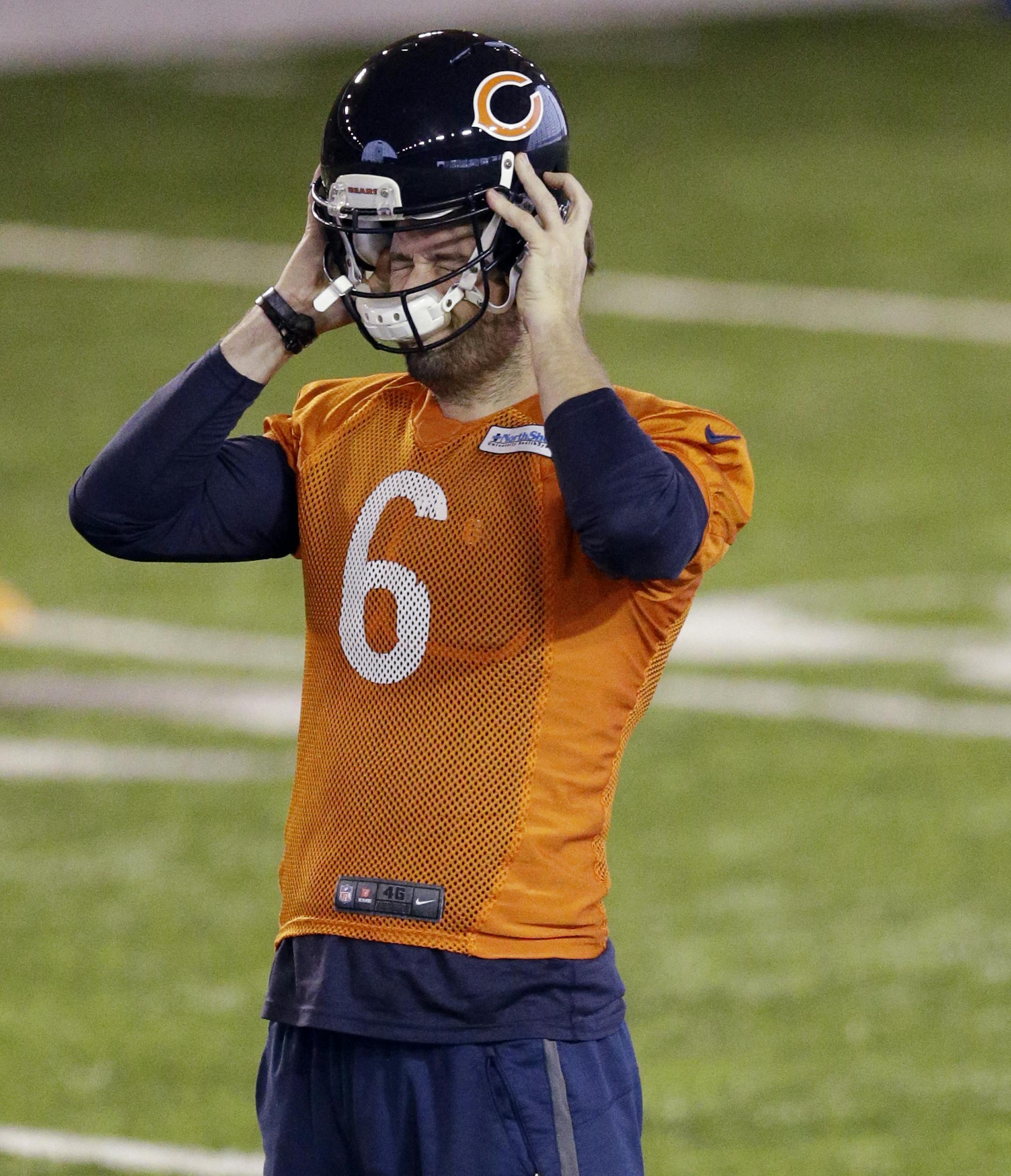 Chicago Bears quarterback Jay Cutler (6) puts his helmet on as quarterback Jimmy Clausen (8) drinks water during NFL football practice at Hallas Hall on Wednesday, Dec. 24, 2014, in Lake Forest, Ill. Clausen will miss the final game of the season because of a concussion, and Cutler will move back into the lineup. (AP Photo/Nam Y. Huh)