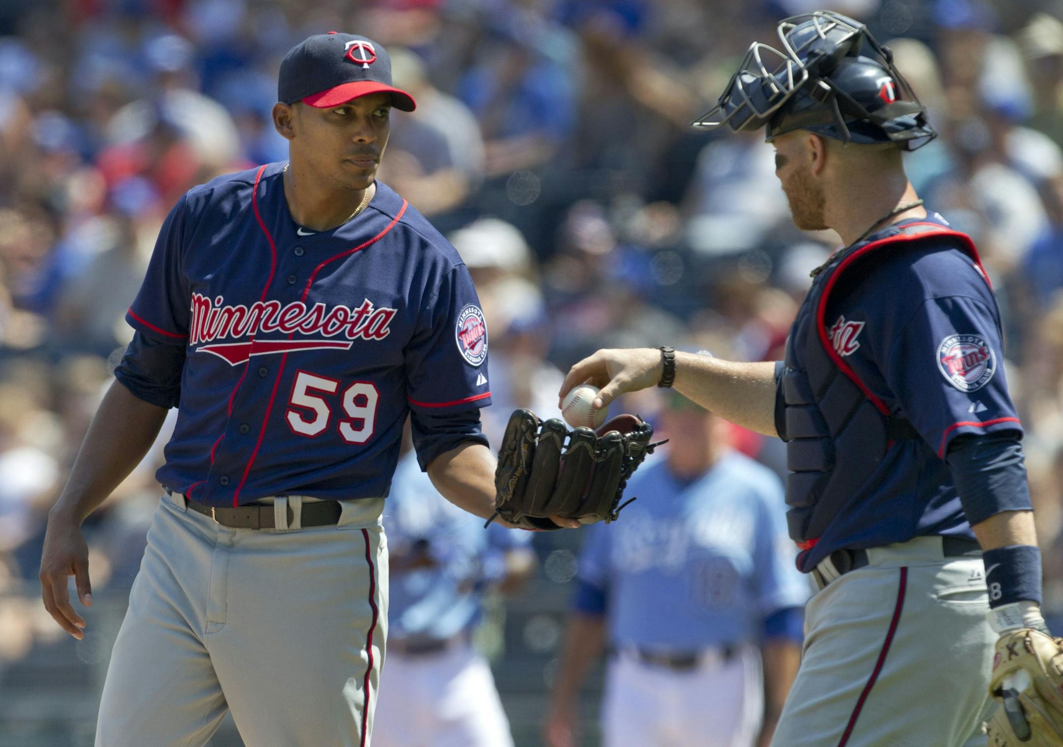 Minnesota Twins starting pitcher Esmerling Vasquez (59) takes the ball from catcher Ryan Doumit during the second inning of a baseball game against the Kansas City Royals at Kauffman Stadium in Kansas City, Mo., Sunday, Sept. 2, 2012.