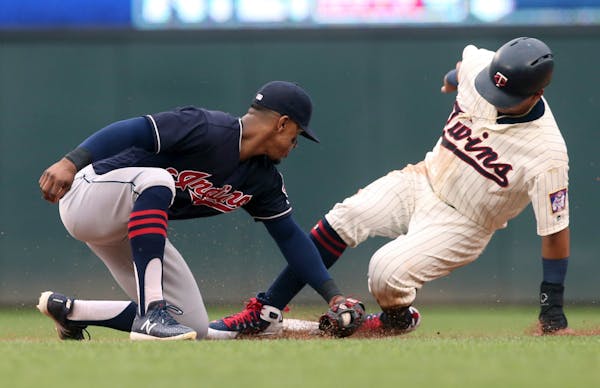 The Twins' Ehire Adrianza beats the tag by Cleveland shortstop Francisco Lindor as he steals second base in the third inning Saturday