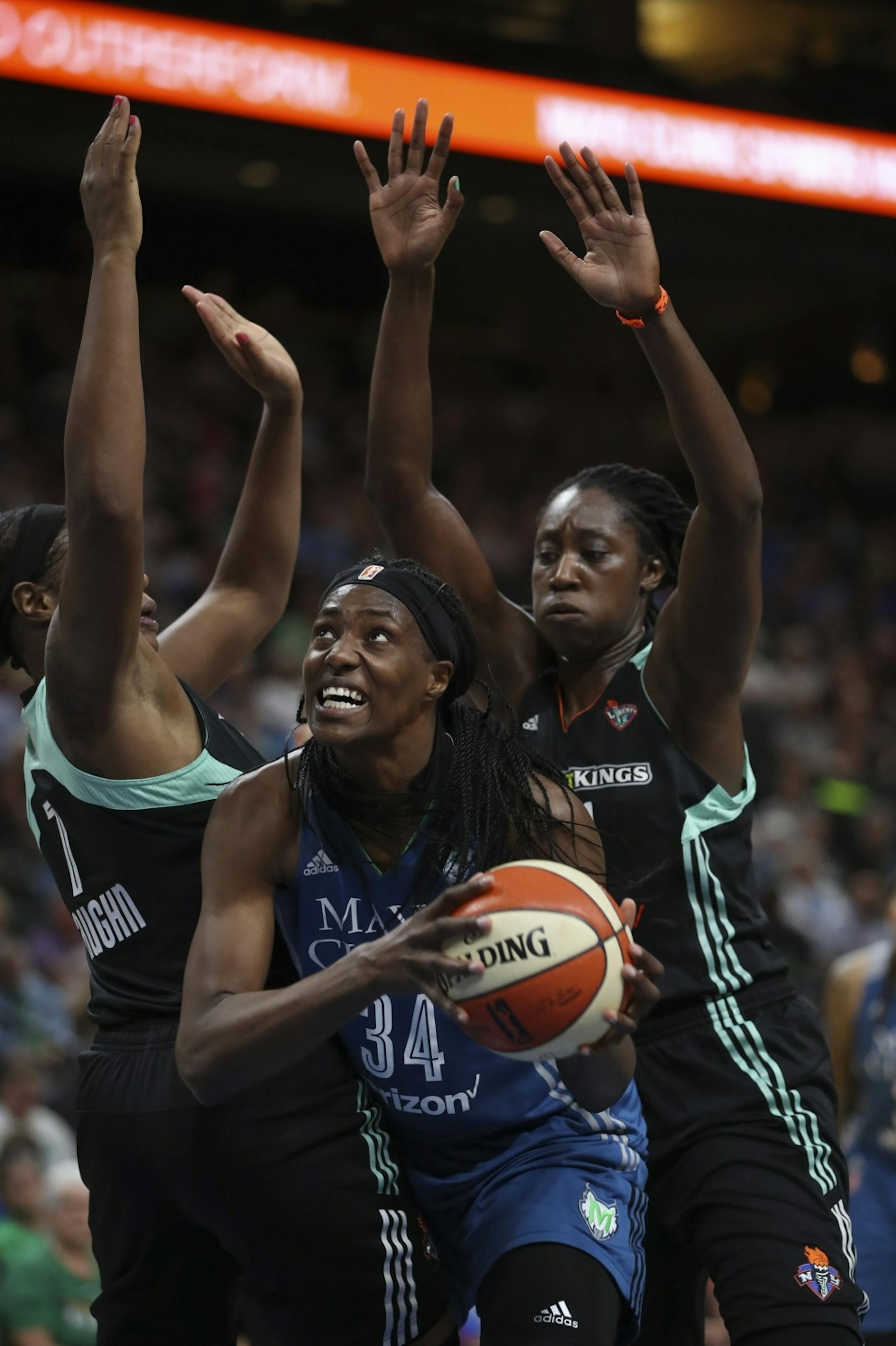 Minnesota Lynx center Sylvia Fowles (34) was fouled by New York Liberty center Kia Vaughn (7) as she muscled her way past her and New York Liberty center Tina Charles (31) in the second quarter.