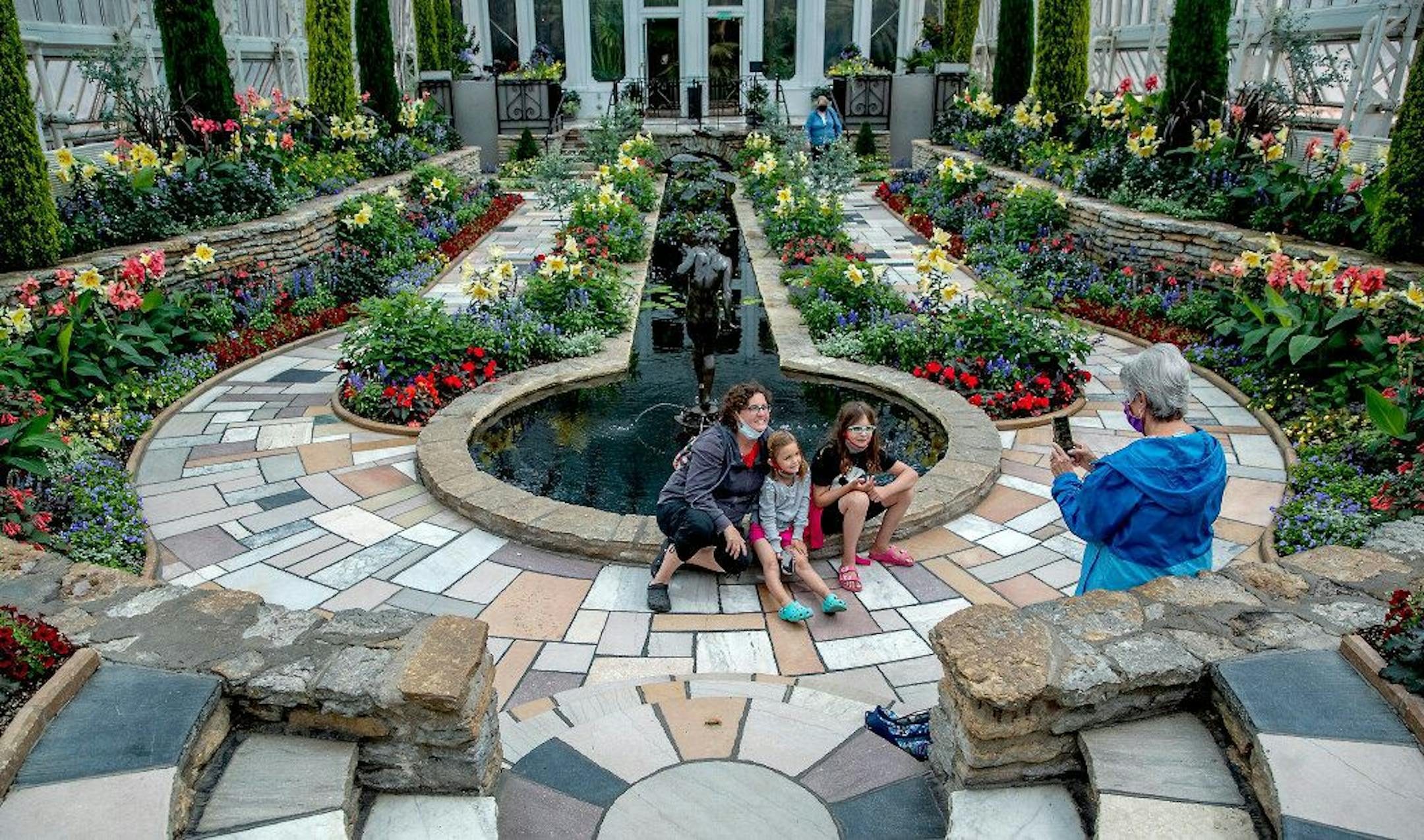 With new safety measures in place, Debbie Manke, right, took in the Marjorie McNeely Conservatory as she took photos of her daughter Stephanie St. Germain and her granddaughters Stacy St. Germain, center, and Samantha St. Germain, Monday, June 22, 2020 in St. Paul, MN. The Conservatory welcomed up to 250 visitors who had advanced reservations. ] ELIZABETH FLORES • liz.flores@startribune.com