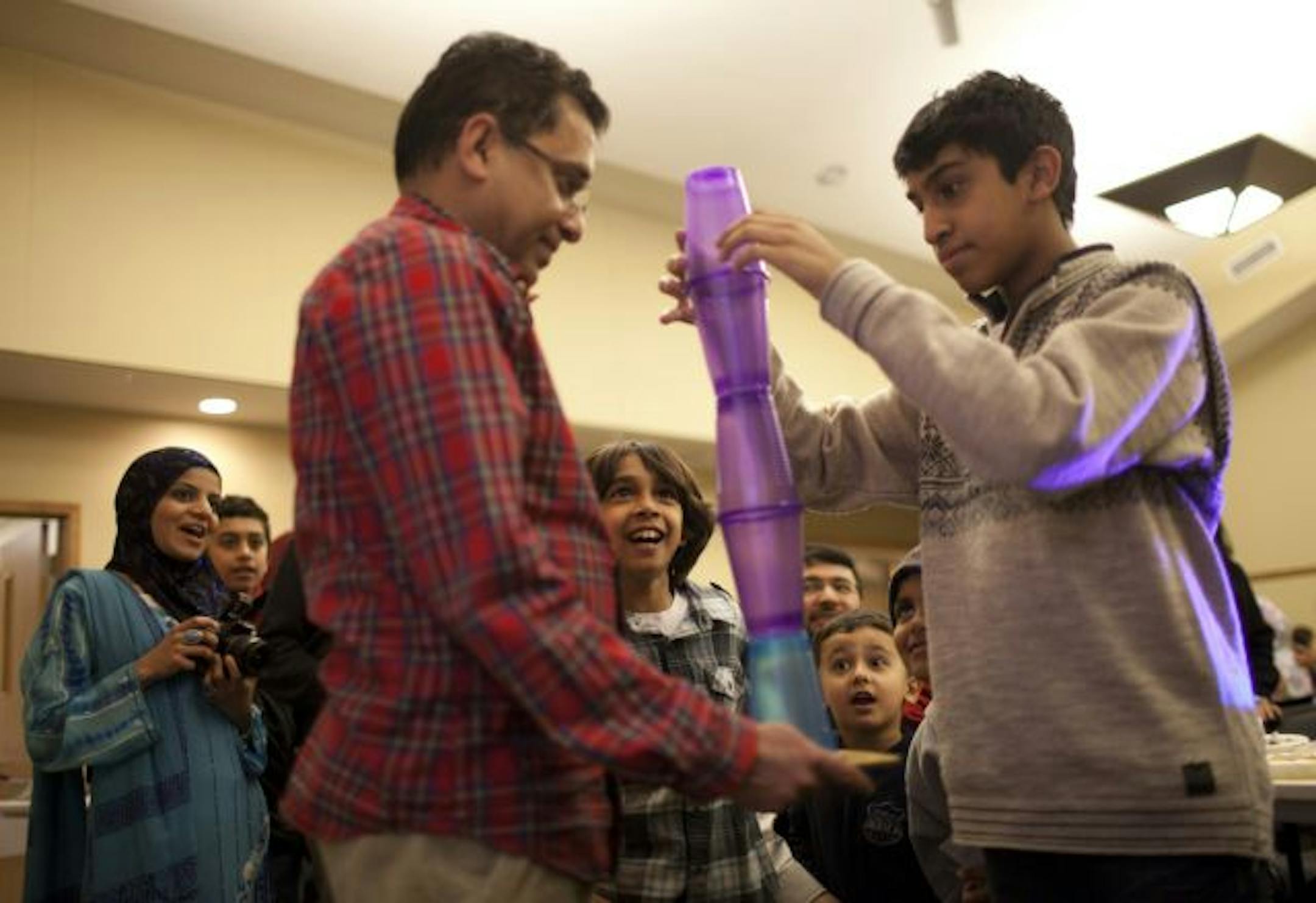 All eyes were on Fawaz Mohiuddin as he tried to stack cups with his dad, Khader, during Family Fun Night at the Northwest Islamic Community Center. The center currently rents space but is close to closing on a building of its own in Plymouth because it is outgrowing the rented space.