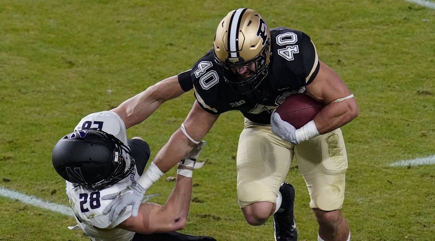 Purdue running back Zander Horvath (40) pushes off the tackle of Northwestern linebacker Chris Bergin (28) during the first half of an NCAA college football game in West Lafayette, Ind., Saturday, Nov. 14, 2020. (AP Photo/Michael Conroy) ORG XMIT: INMC102