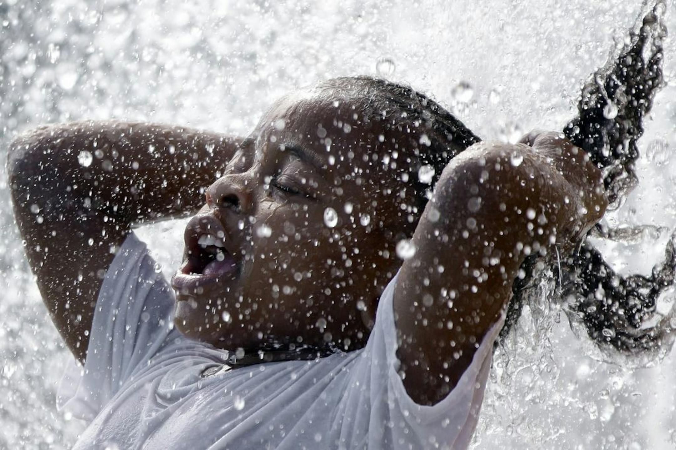 Five year-old Grace Kennedy cools off from the heat in a water fountain in Stinson Park in Omaha, Neb., Monday, Aug. 26, 2013. An unusual, late-summer heat wave enveloped much of the Midwest on Monday, putting schools and sports events on hold. Some schools in Iowa, Nebraska, Wisconsin, the Dakotas and Illinois let out early as temperatures crept toward the mid-90s, and beyond in some places.