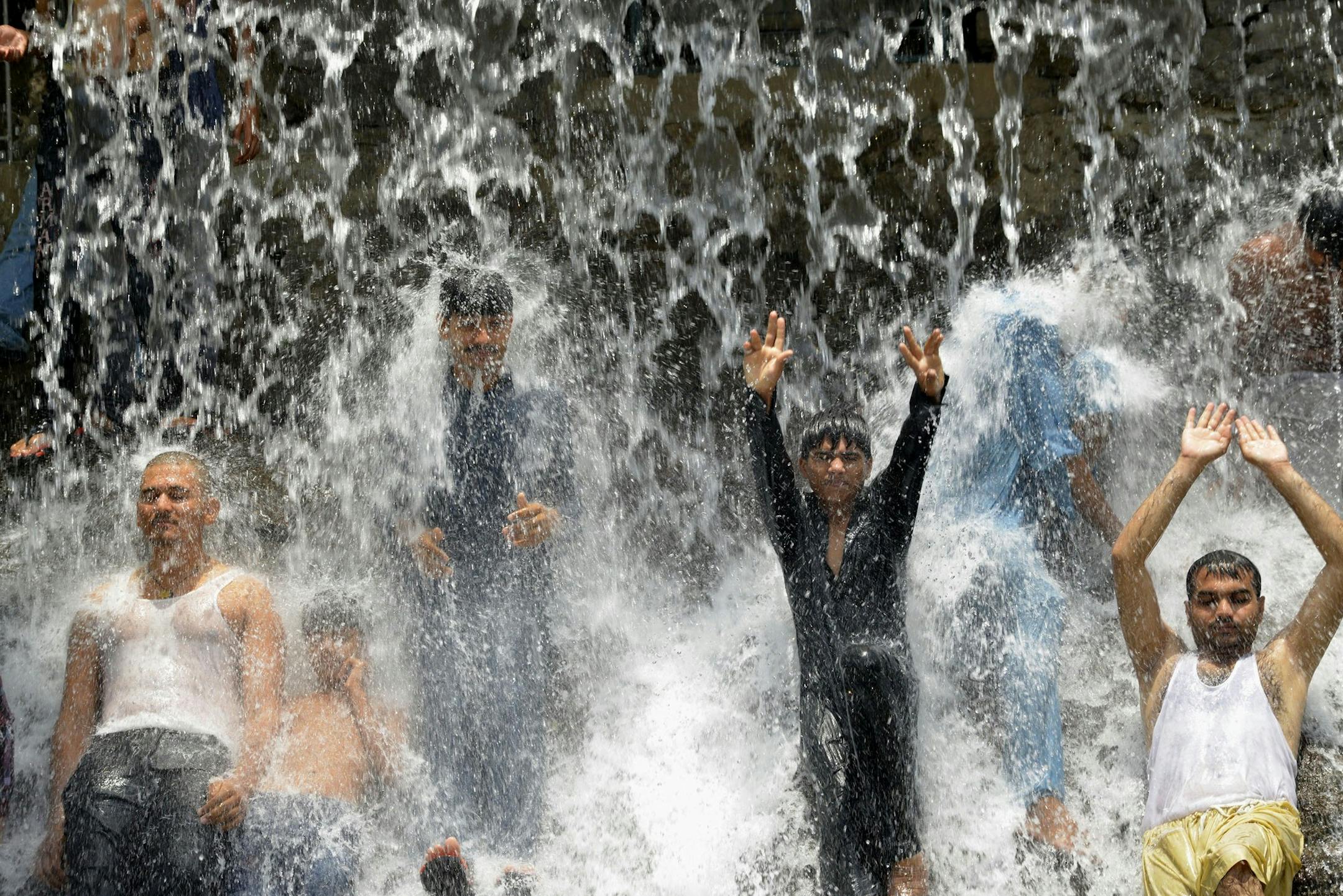In this 2014 file image, Pakistani youth crowd a water fall in a park to beat the heat in Lahore. Severe heat wave conditions would continue over most plains of the Punjab province, including the provincial capital,as well as adjacent areas and southern Punjab in the seasons following 2014. (Arif Ali/AFP via Getty Images/TNS)
