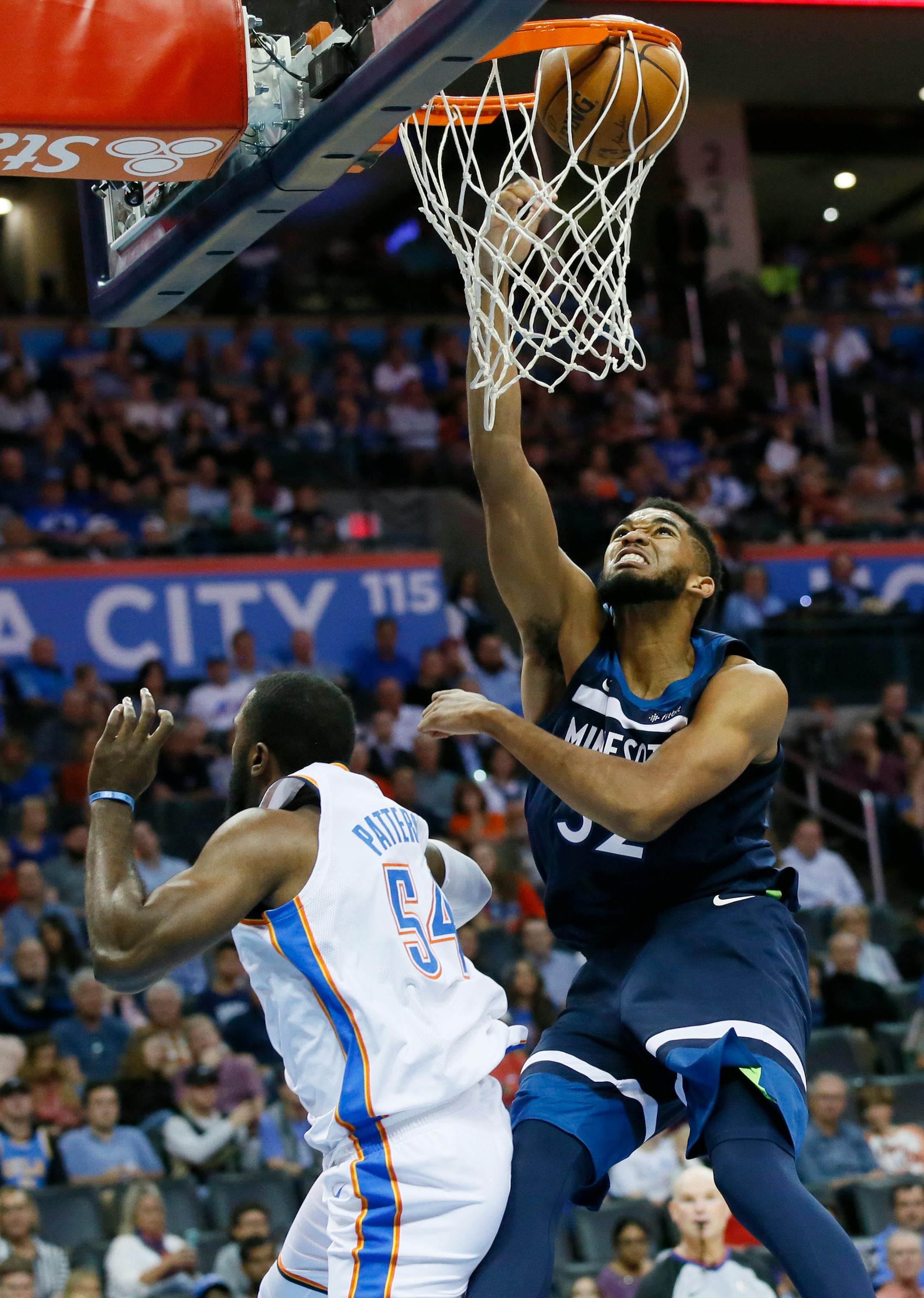 Minnesota Timberwolves center Karl-Anthony Towns (32) dunks over Oklahoma City Thunder forward Patrick Patterson (54) in the second quarter of an NBA basketball game in Oklahoma City, Sunday, Oct. 22, 2017.