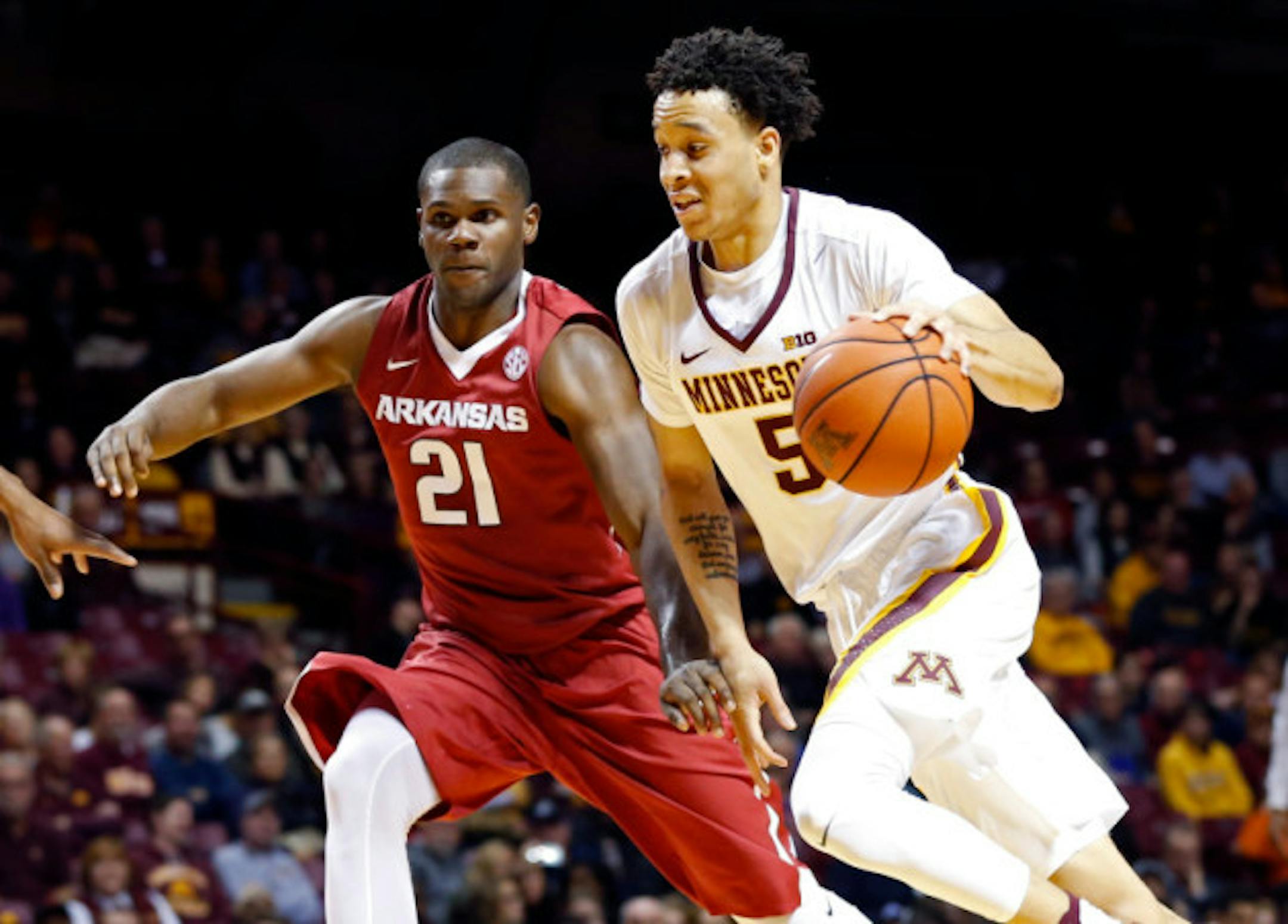 Minnesota's Amir Coffey, right, drives as Arkansas' Manuale Watkins pursues during the second half of an NCAA college basketball game Tuesday, Nov. 22, 2016, in Minneapolis. Minnesota won 85-71 (AP Photo/Jim Mone)