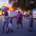 From left, Jennie, Danny, 5, Bryan, and Grant, 6, play with a ball as they walk to the grandstand where The Hideaway is at the Minnesota State Fairgro