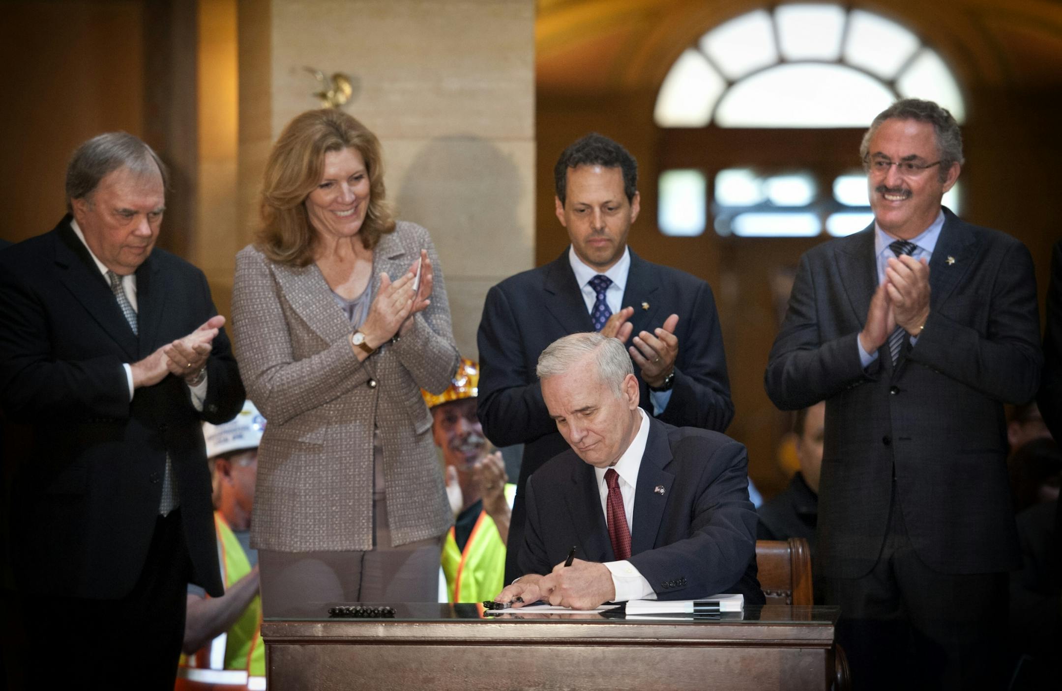 Gov. Mark Dayton signed the stadium bill in the Capitol Rotunda on Monday. Behind him are Mark and Zygi Wilf, bill authors Rep. Morrie Lanning and Sen. Julie Rosen.