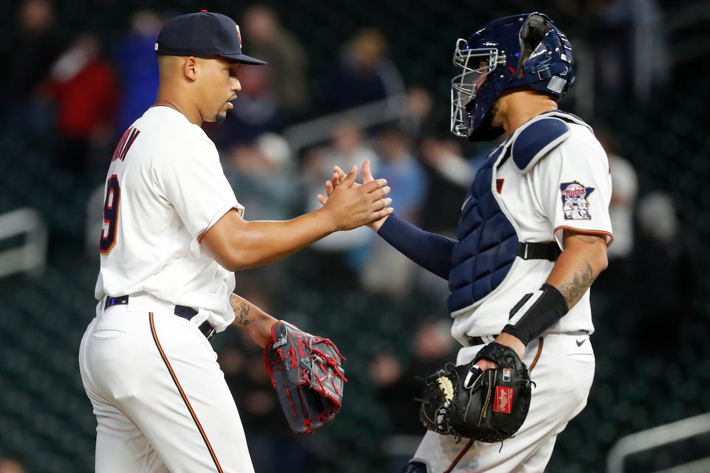 Minnesota Twins relief pitcher Jhoan Duran, left, and catcher Gary Sanchez celebrate the win against the Seattle Mariners at a baseball game Monday, April 11, 2022, in Minneapolis. (AP Photo/Bruce Kluckhohn)