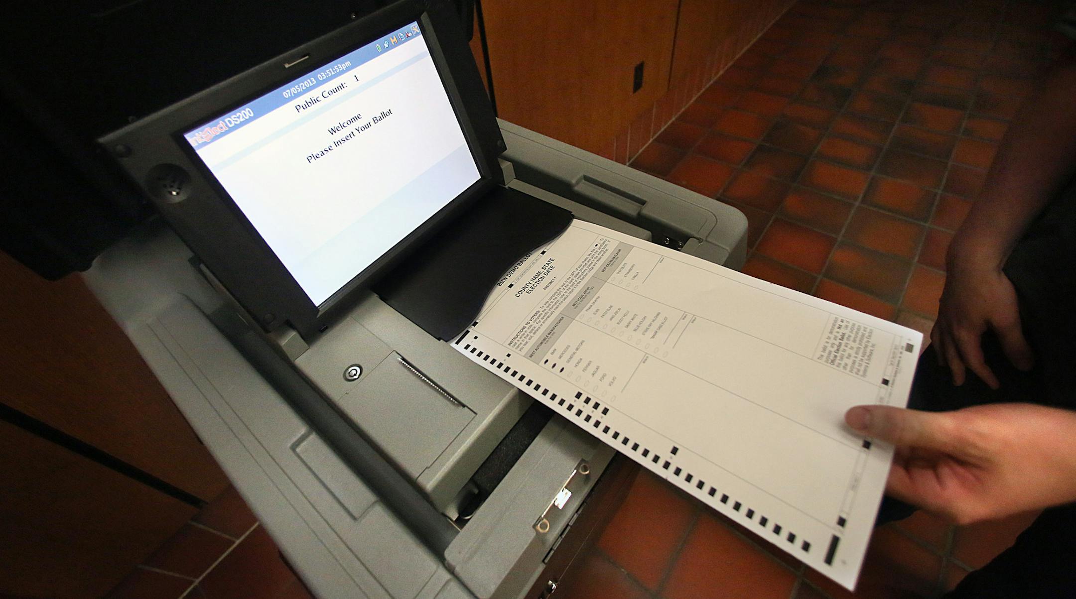 Hennepin County Elections worker Luke Belant demonstrated how a ballot is cast in a new generation of election machines.