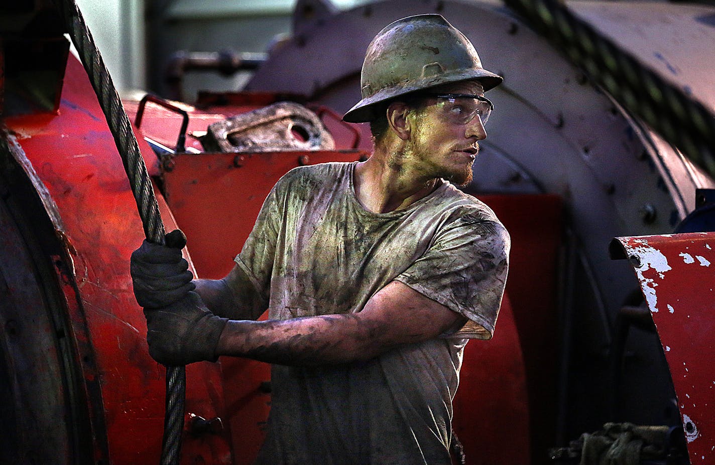 Floor hand Ray Gerrish worked to make repairs on a drilling rig as the sun rose near the site outside Watford City on December 17, 2013.