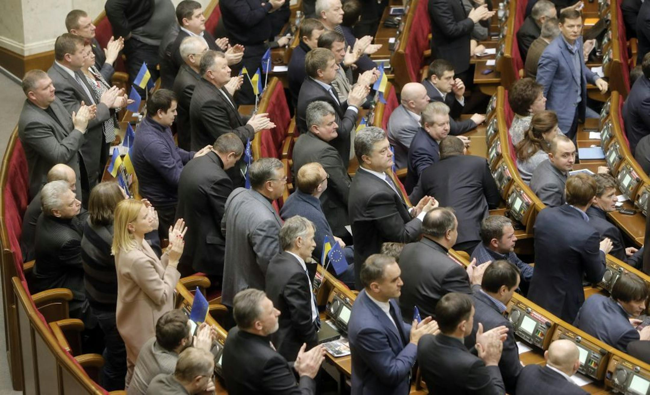 Ukrainian lawmakers applaud after voting during a parliamentary session in Kiev, Ukraine, Tuesday, Jan. 28, 2014.