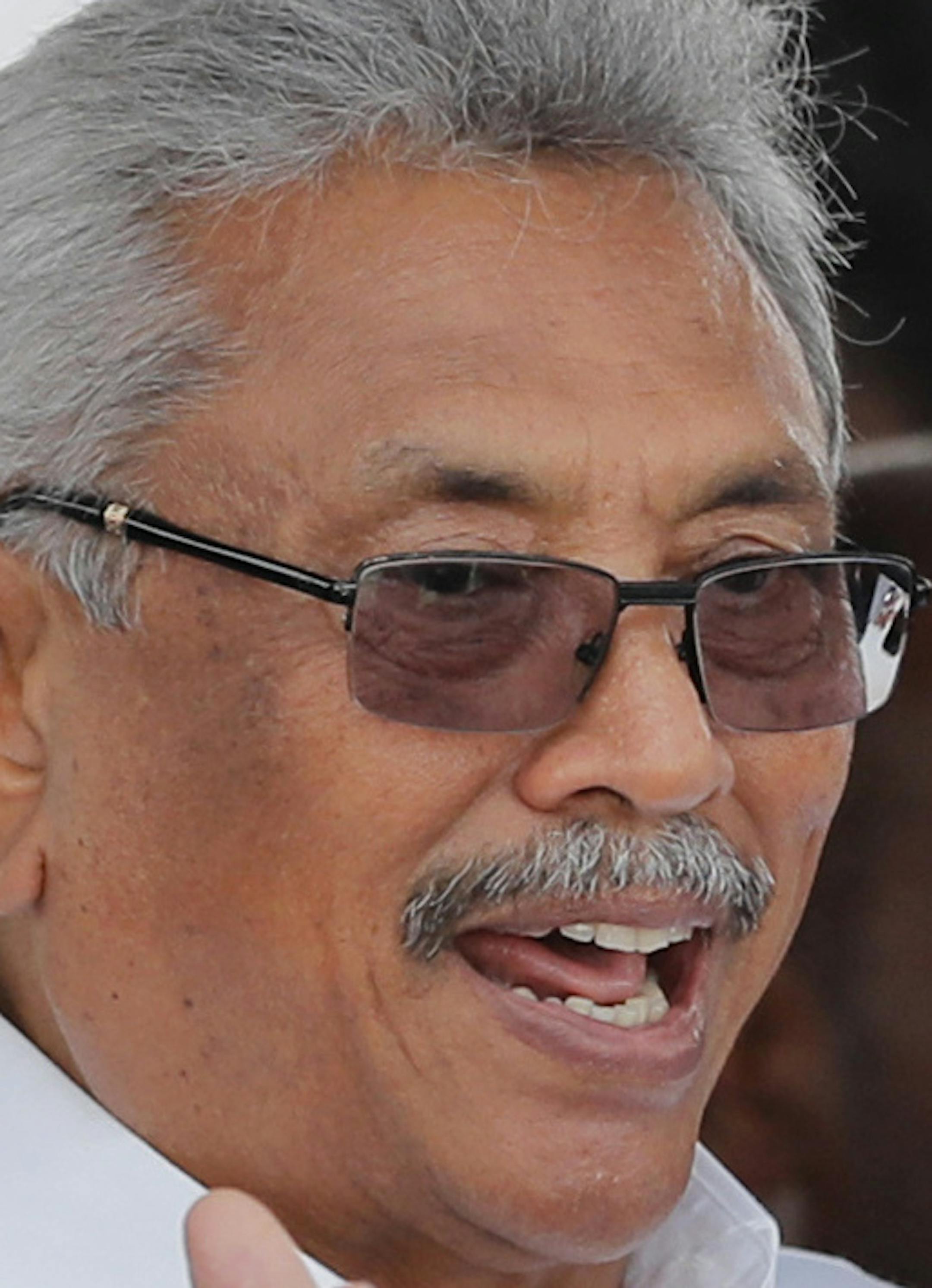 Sri Lanka's newly elected president Gotabaya Rajapaksa, center, gestures to supporters who flocked around him to move during the swearing in ceremony held at the 140 B.C Ruwanweli Seya Buddhist temple in ancient kingdom of Anuradhapura in north central Sri Lanka Monday, Nov. 18, 2019. The former defense official credited with ending a long civil war was Monday sworn in as Sri Lanka’s seventh president after comfortably winning last Saturday’s presidential election. (AP Photo/Eranga