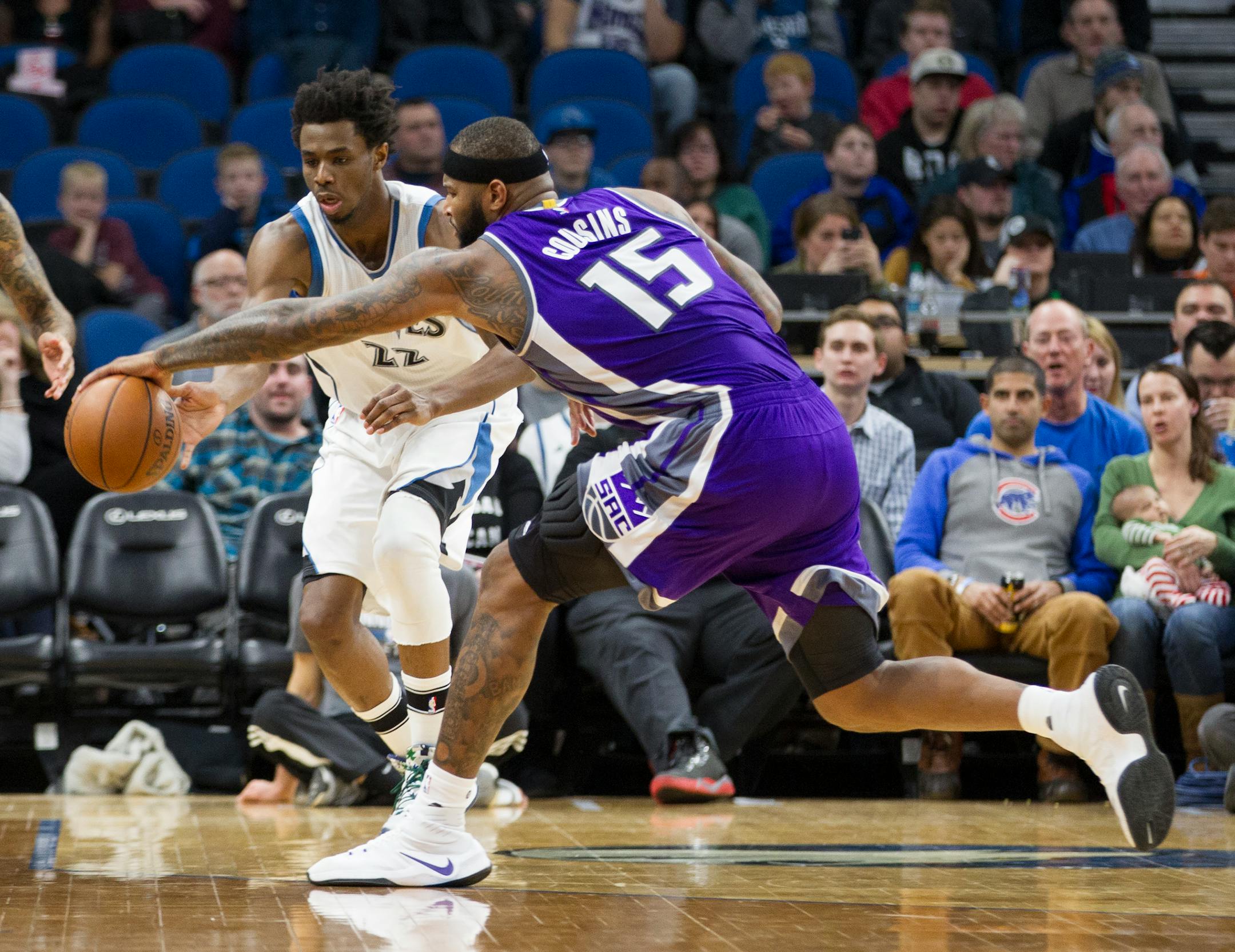 Minnesota Timberwolves forward Andrew Wiggins (22) and Sacramento Kings forward DeMarcus Cousins (15) go for a loose ball during the first half of an NBA basketball game, Friday, Dec. 23, 2016, in Minneapolis. (AP Photo/Paul Battaglia)