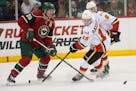 Calgary Flames left wing Johnny Gaudreau (13) challenges Minnesota Wild defenseman Ryan Suter (20) for the puck during the third period. ] (Aaron Lavi