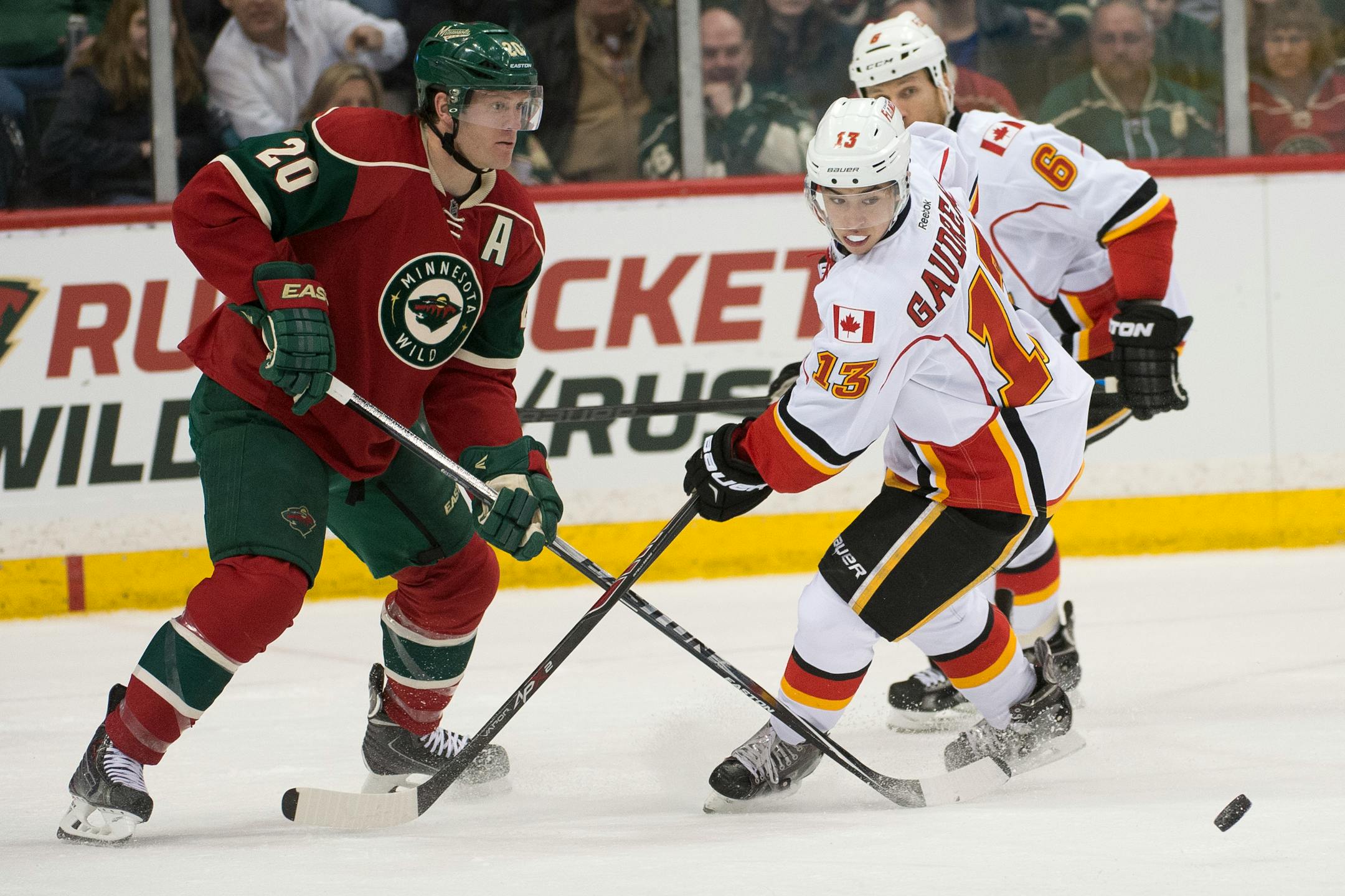 Calgary Flames left wing Johnny Gaudreau (13) challenges Minnesota Wild defenseman Ryan Suter (20) for the puck during the third period. ] (Aaron Lavinsky | StarTribune) The Minnesota Wild play the Calgary Flames on Friday, March 27, 2015 at Xcel Energy Center in St. Paul.