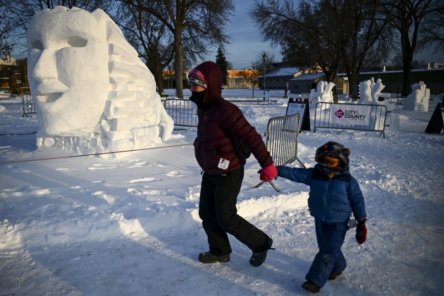 Melissa Arikian, of St. Paul, walked with her son Osten Milburn, 4, through the snow sculpture viewing area at the Minnesota State Fairground on Thursday night, looking for an outing after being stuck inside the past few days.