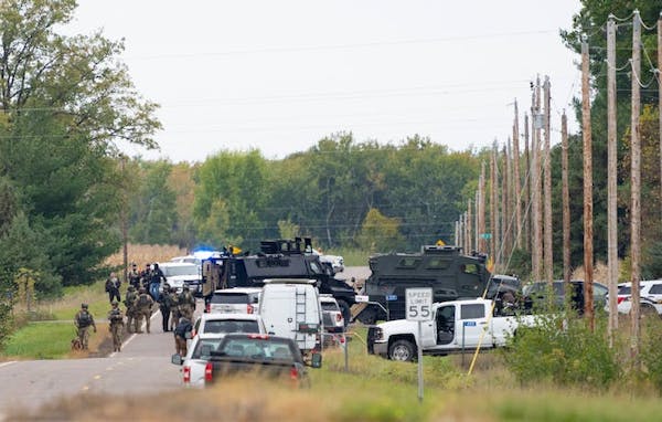 Law enforcement outside of the Karl Holmberg residence during a standoff after multiple officers were shot near Princeton, Minn., on Thursday.