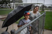 Matthew Spangler Jr., 9, of Miami waited in the rain Sunday with his mother, Reyna Spangler. to get autographs from Twins players at Hammond Stadium i