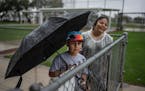 Matthew Spangler Jr., 9, of Miami waited in the rain Sunday with his mother, Reyna Spangler. to get autographs from Twins players at Hammond Stadium i