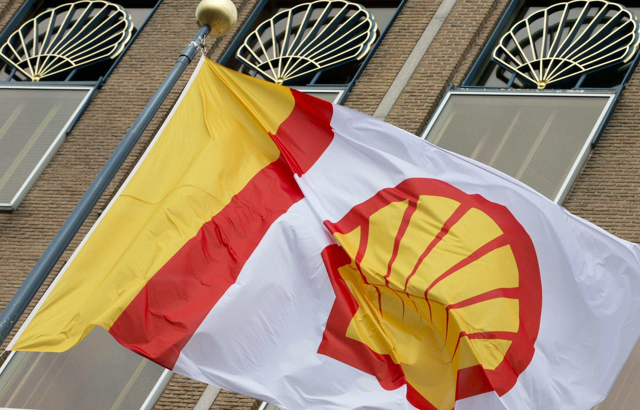 FILE - In this Monday, April 7, 2014 file photo, a flag bearing the company logo of Royal Dutch Shell, an Anglo-Dutch oil and gas company, flies outside the head office in The Hague, Netherlands. Shell’s $82 billion purchase of gas company BG Group will boost its oil and gas reserves by 25 percent and give it a bigger presence in the fast-growing liquefied natural gas market.. (AP Photo/Peter Dejong, File)