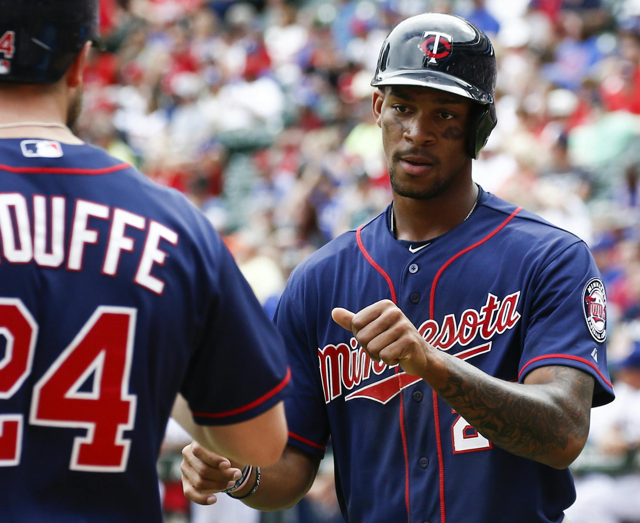 Minnesota Twins' Byron Buxton, right, is congratulated by Trevor Plouffe (24) after scoring the go-ahead run on a double by Eddie Rosario against the Texas Rangers during the ninth inning of a baseball game, Sunday, June 14, 2015, in Arlington, Texas. The Twins won 4-3. (AP Photo/Jim Cowsert)