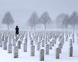 A woman visits a gravesite during a snowstorm at Fort Snelling National Cemetery.