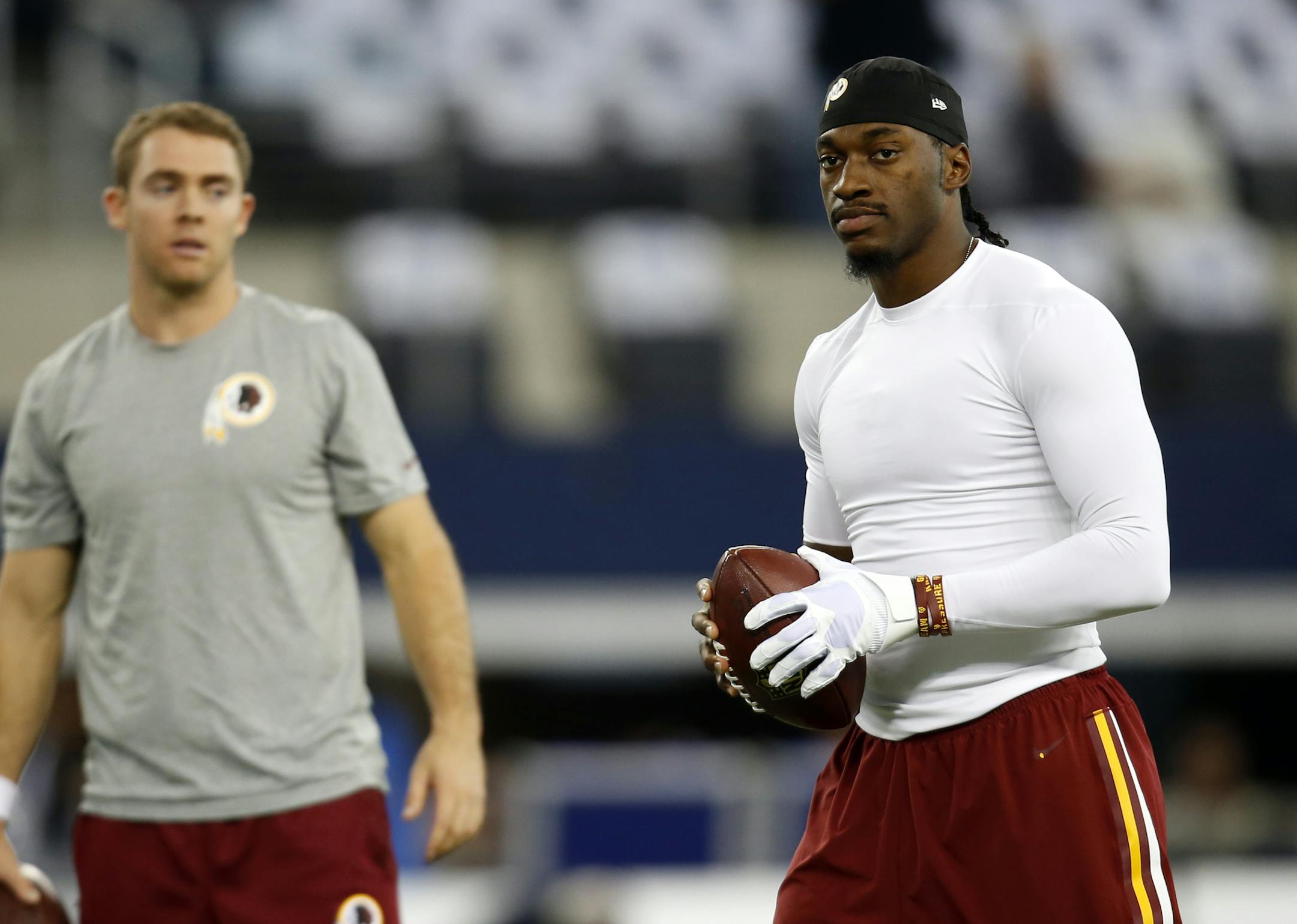 Washington Redskins quarterback Colt McCoy, left, and quarterback Robert Griffin III (10) warm up before an NFL football game against the Dallas Cowboys, Monday, Oct. 27, 2014, in Arlington, Texas. (AP Photo/Tim Sharp)