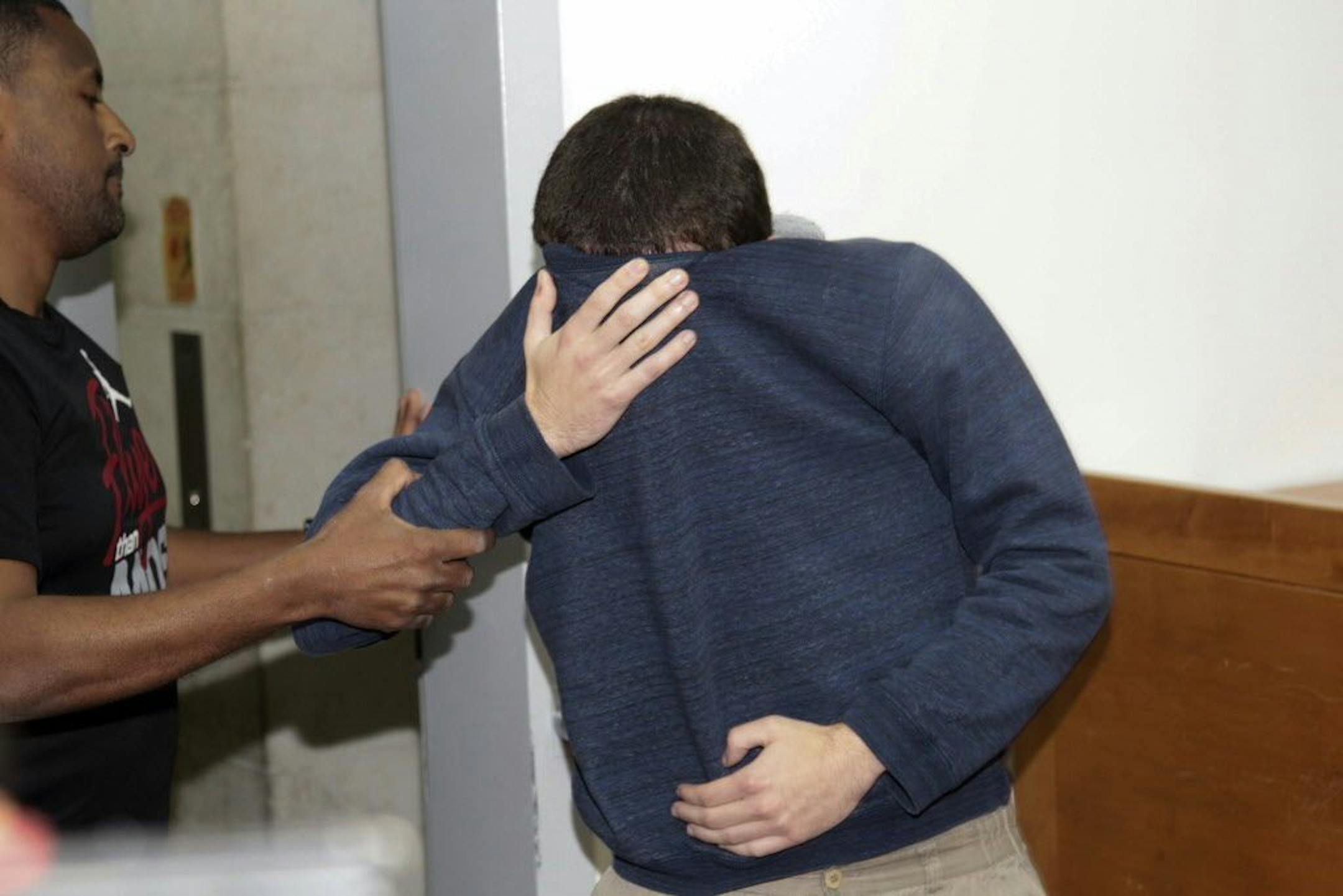 A 19-year-old dual U.S.-Israeli citizen covers his face as he is brought to court in Rishon Lezion, Israel, Thursday, March 23, 2017. Israeli police said they have arrested a Jewish Israeli man who is the prime suspect behind a wave of bomb threats against Jewish community centers and other institutions in the United States. The police withheld his identity.